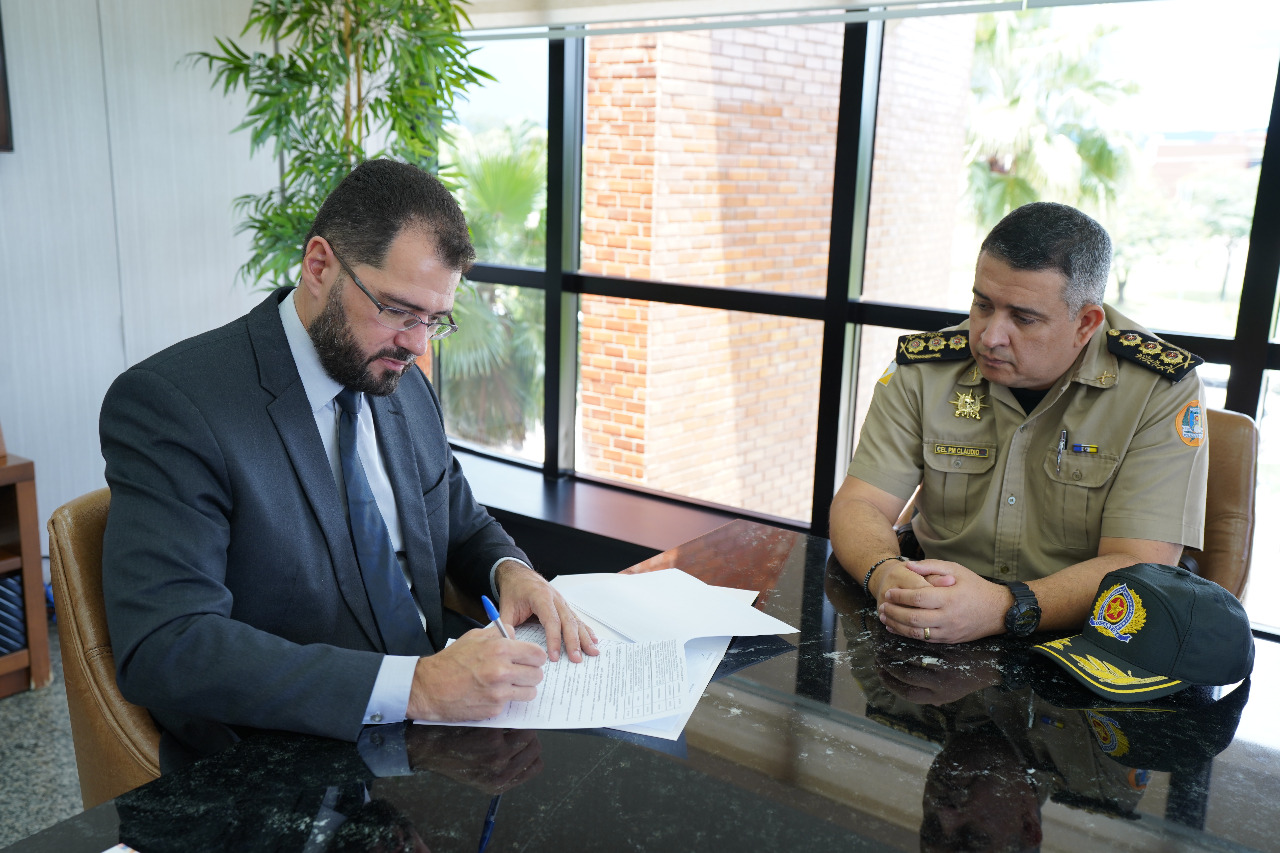 Juiz auxiliar Manoel Alves assinando termo de cessão de imóveis ao lado do Chefe do Estado Maior da PMTO, coronel Cláudio Thomaz Coelho de Souza