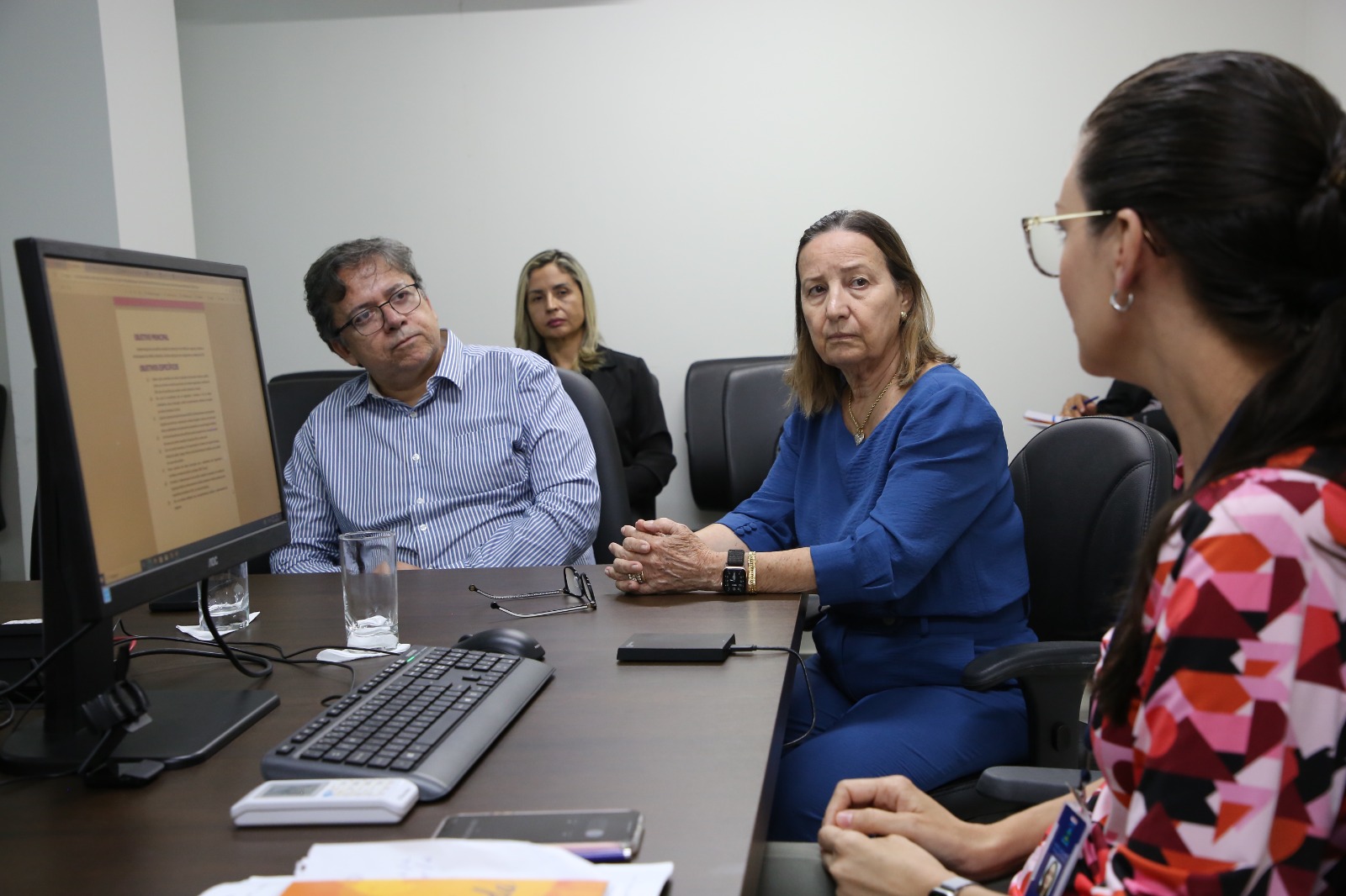 Desembargadora reunida em uma mesa com coordenadora da mulher em situação de violência doméstica