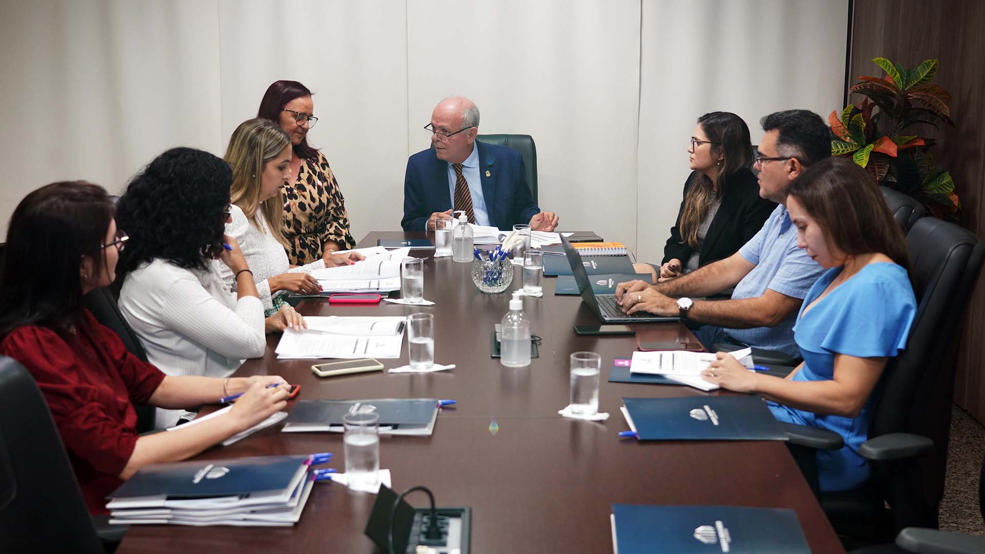 Imagem mostra várias pessoas reunidas em uma mesa para tratar sobre assuntos relacionados à violência doméstica
