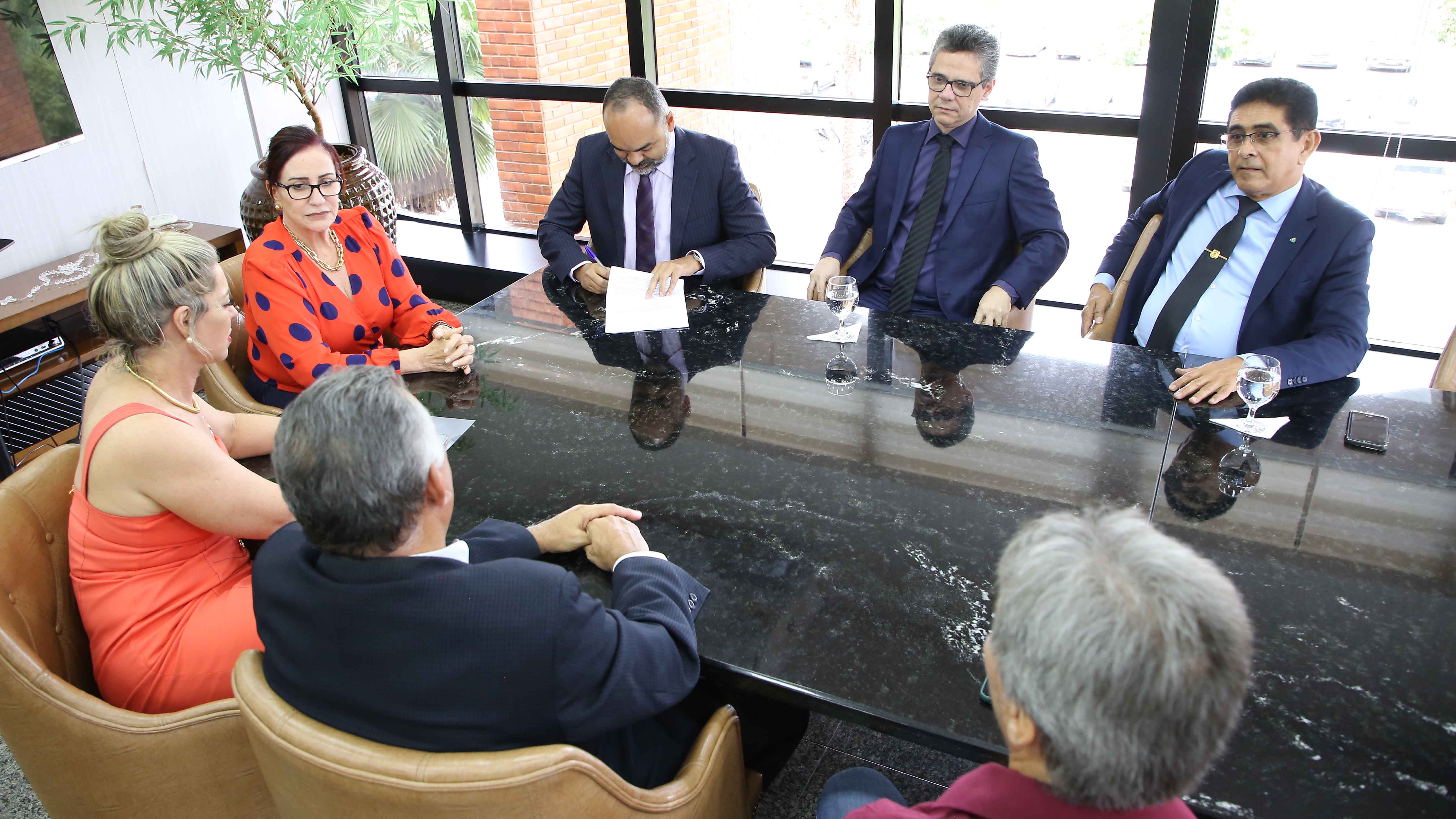 Na imagem, a presidente do TJTO e outras seis pessoas assinam portaria que regulamenta Central de Vagas do Sistema Socioeducativo