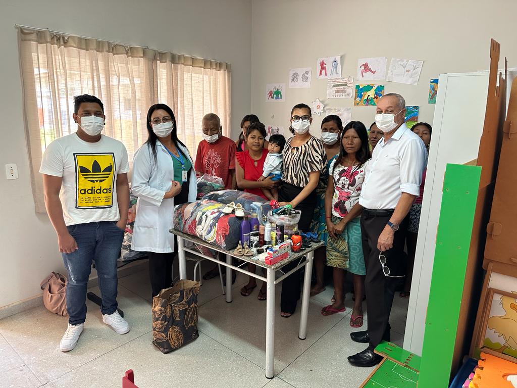 Chefe da Casa de Apoio à Saúde Indígena de Araguaína (CASAI), Mario Luiz Alves Coutinho, posando para foto junto com indígenas beneficiados e com os itens doados entre eles.