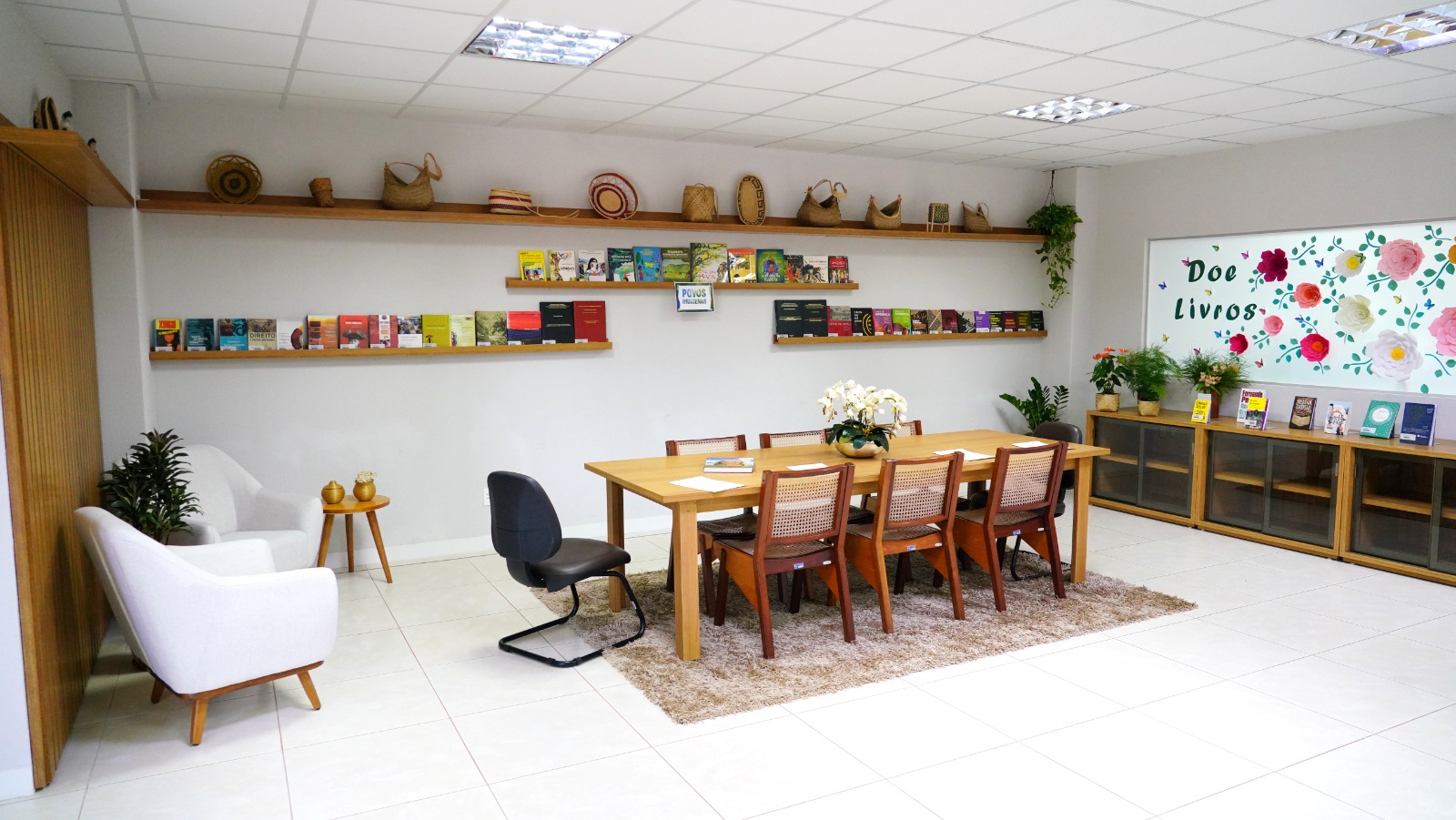 Foto da biblioteca da Esmat com decorações indígenas na prateleira superior 