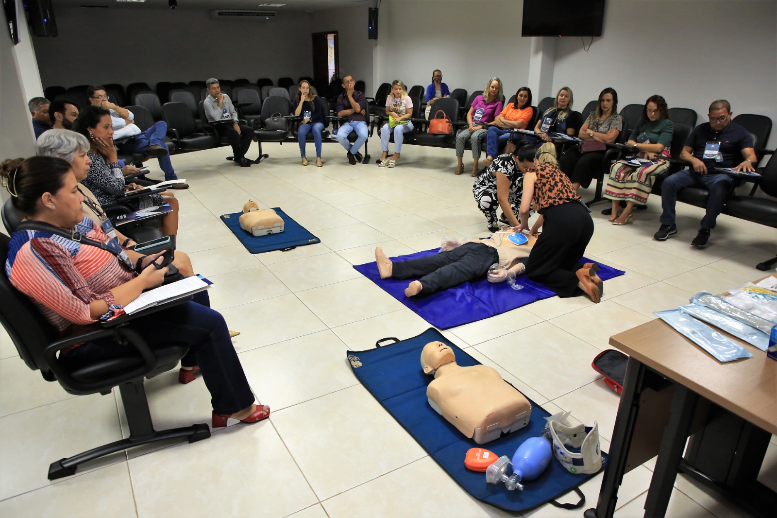 Participantes atentos as instruções de reanimação cardíaca