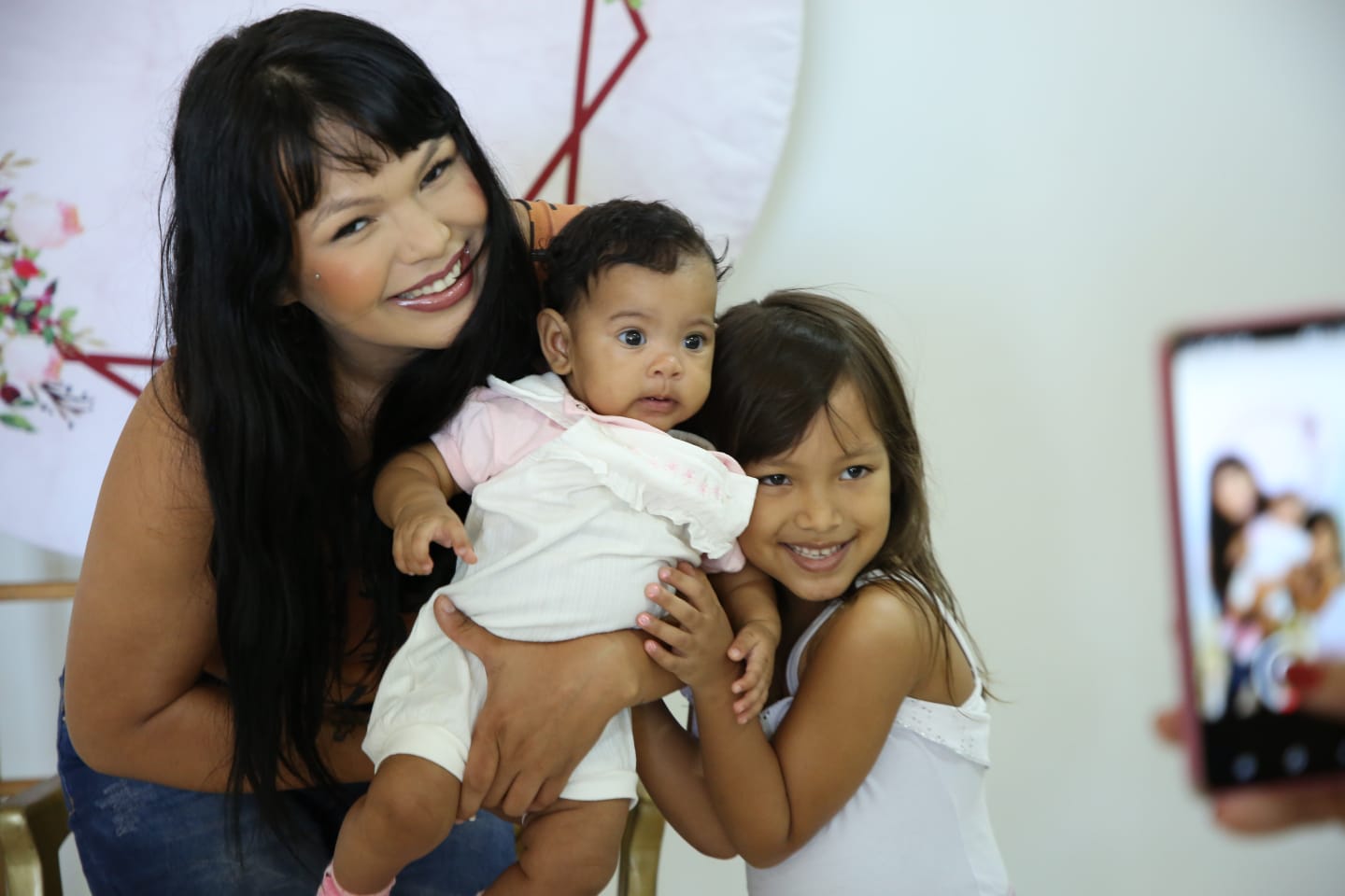 Mãe e filhos posam para foto em evento de Dias das Mães
