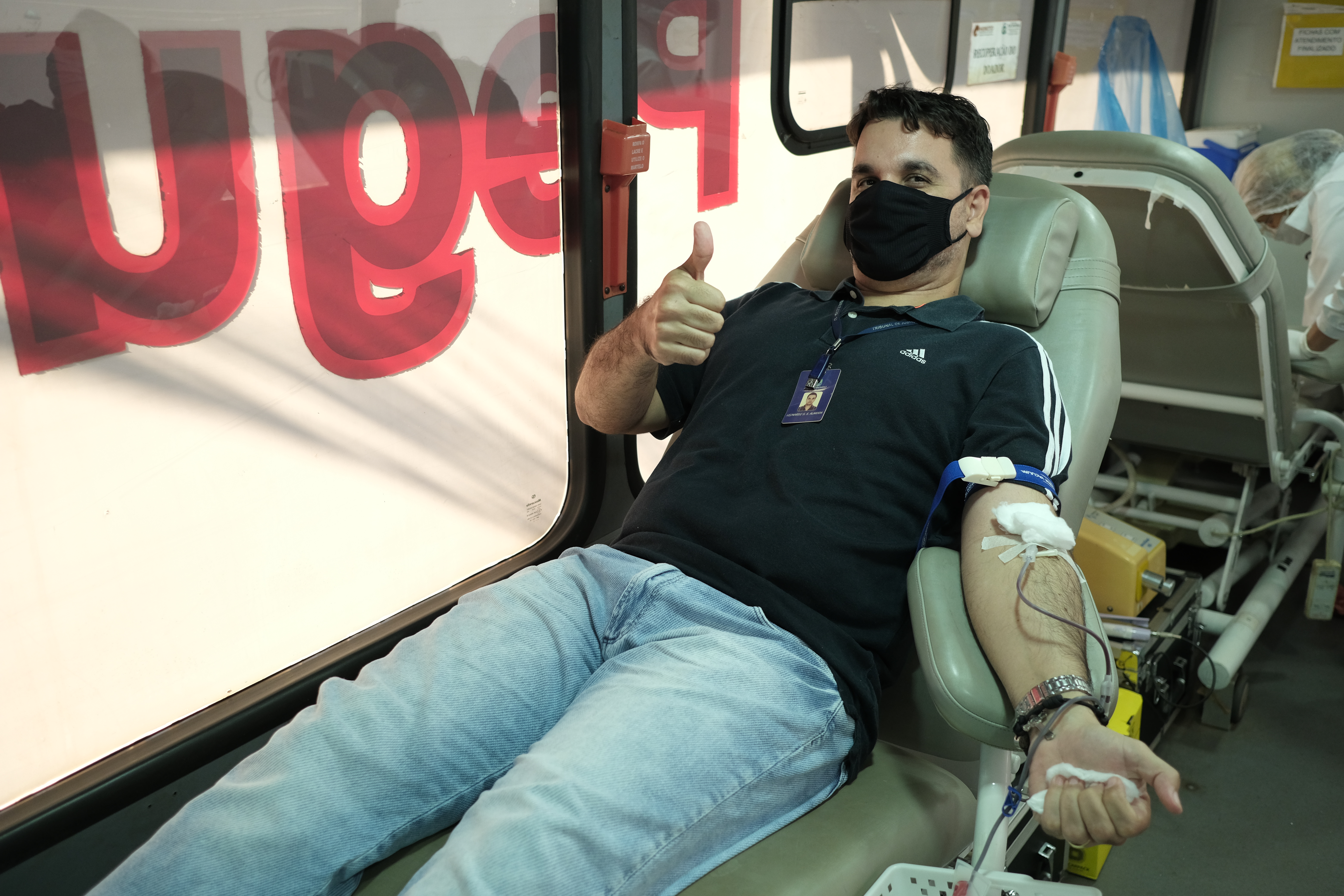 Servidor do TJ realizando coleta de sangue dentro da unidade móvel do hemocentro