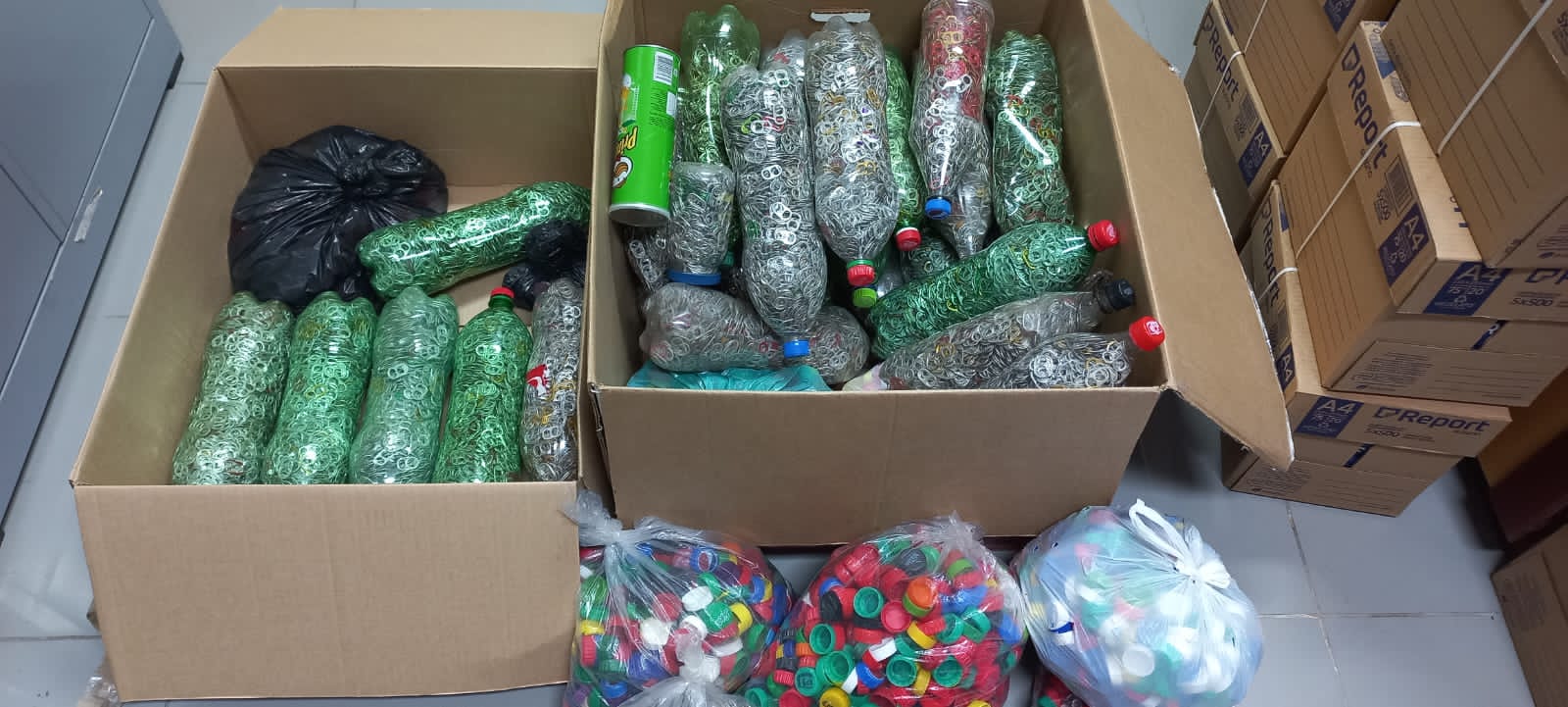 Caixas marrom com os itens de cor verde arrecadados pela Comarca de Dianópolis e alunos da Unitins