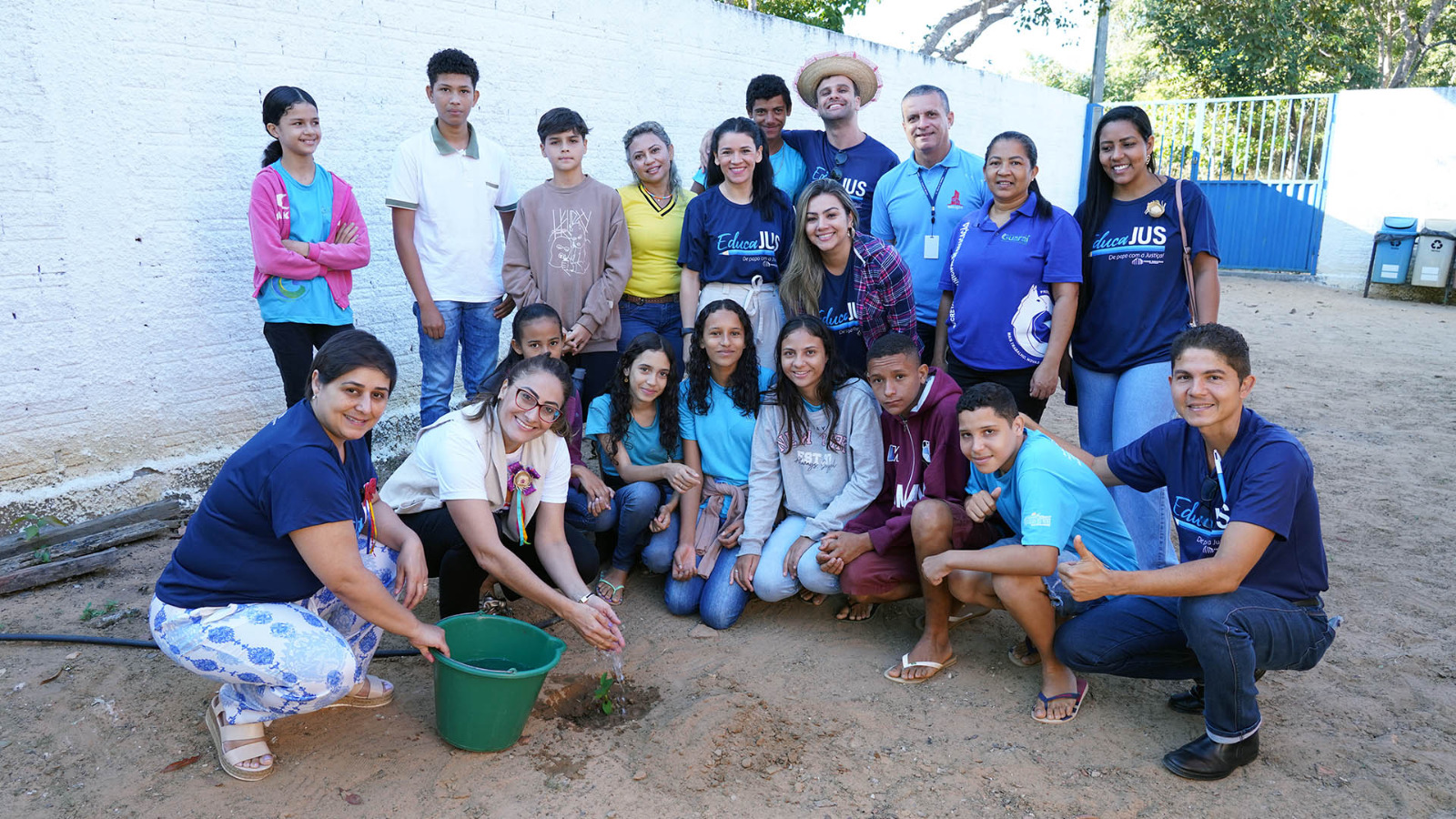 estudantes plantam uma muda de árvore