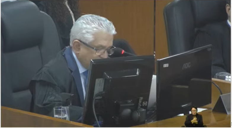 Desembargador Eurípedes Lamounier, de paletó, olhando pra tela do computador