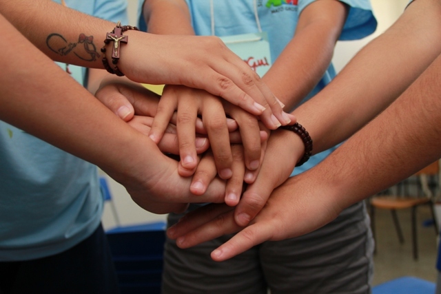 Varias mãos de diversas pessoas amontoadas simbolizando união