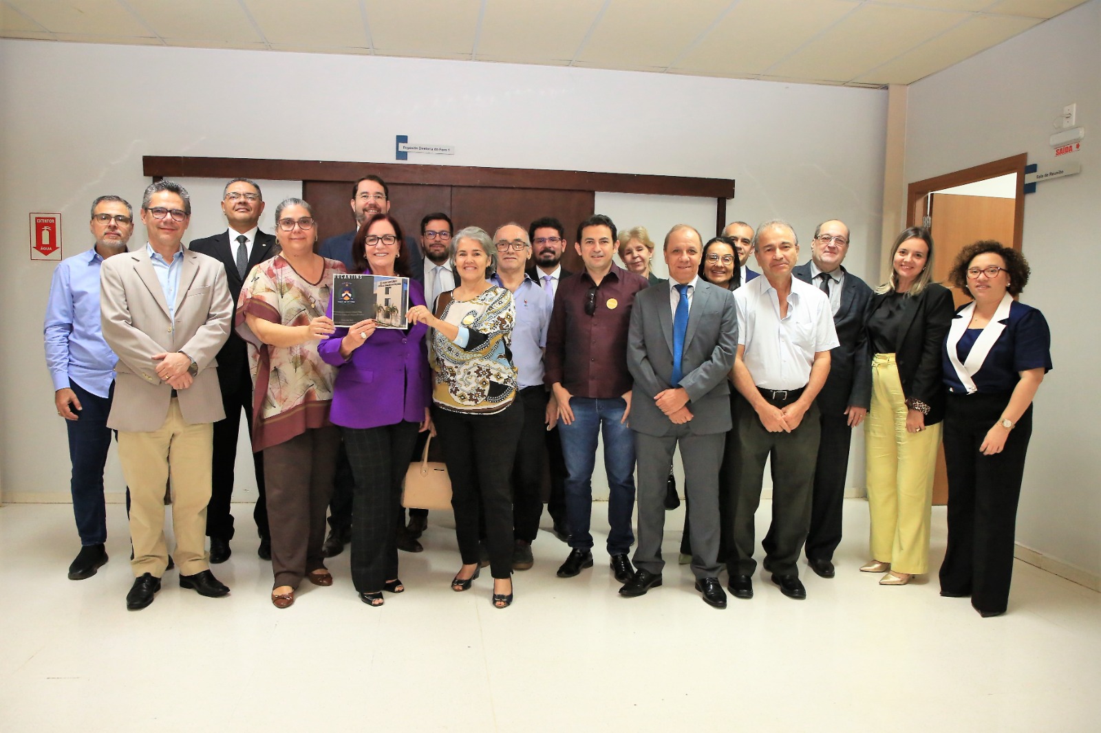 Imagem mostra homens e mulheres sentados ouvindo discurso da presidente do TJTO