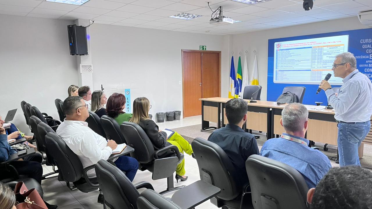 Foto mostra um auditório com várias pessoas sentadas e um palestrante apresentando o Sistema GRP
