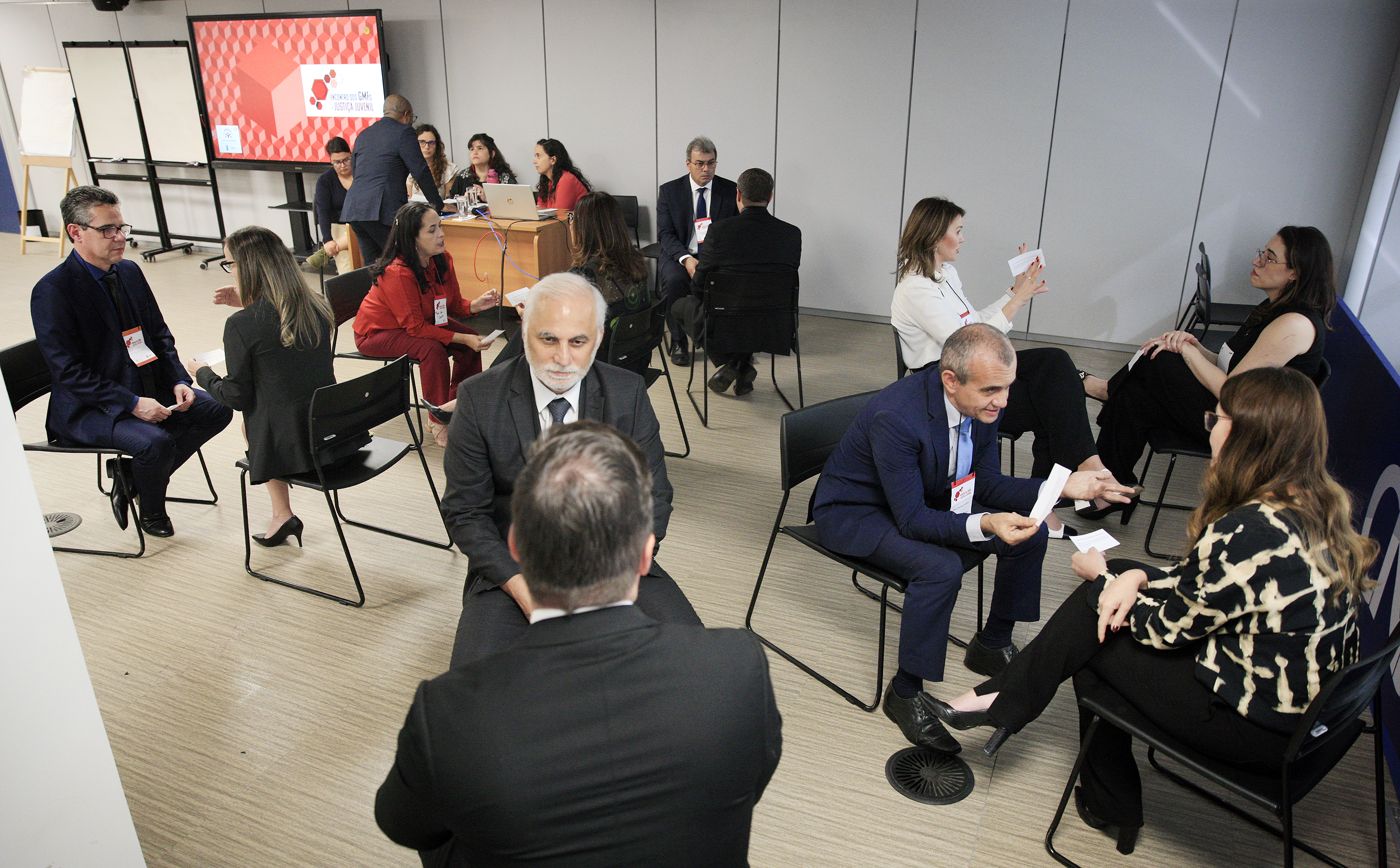 Pessoas sentadas em uma sala conversando 