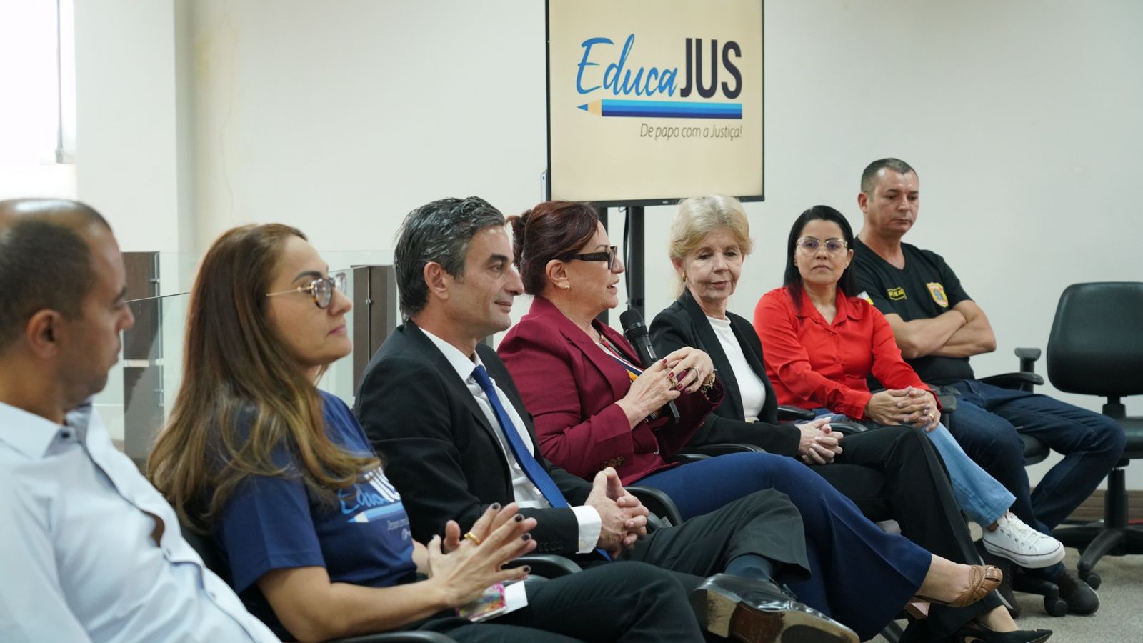 Presidente do TJTO sentada e falando com participantes do projeto segurando um microfone