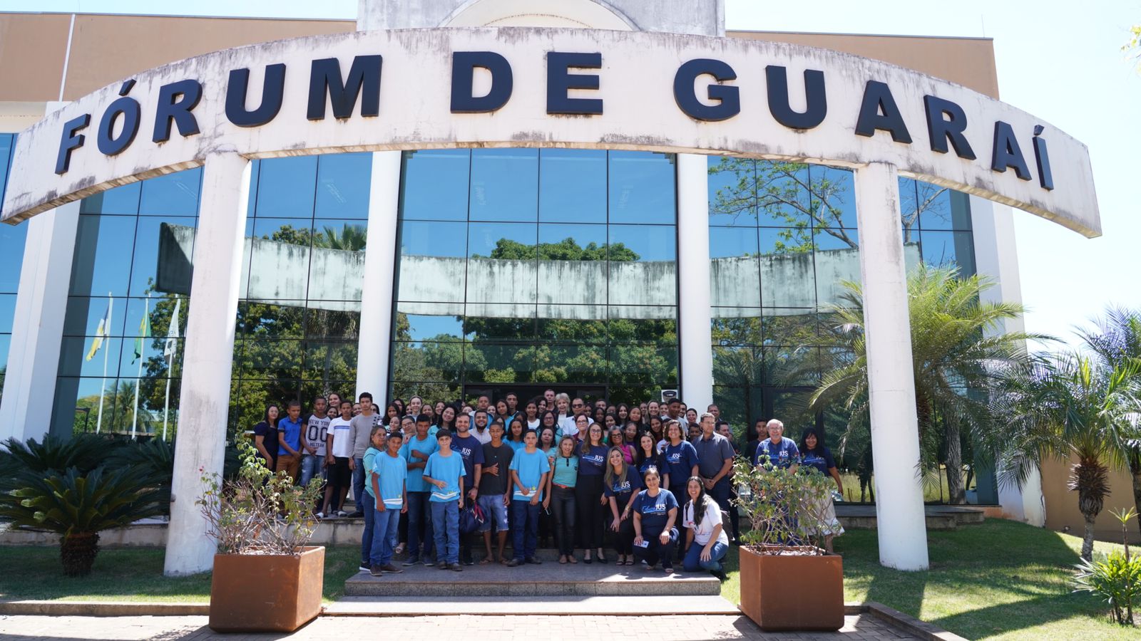 Participantes e organizadores do projeto Educajus reunidos em frente ao Fórum da Guaraí posando para foto