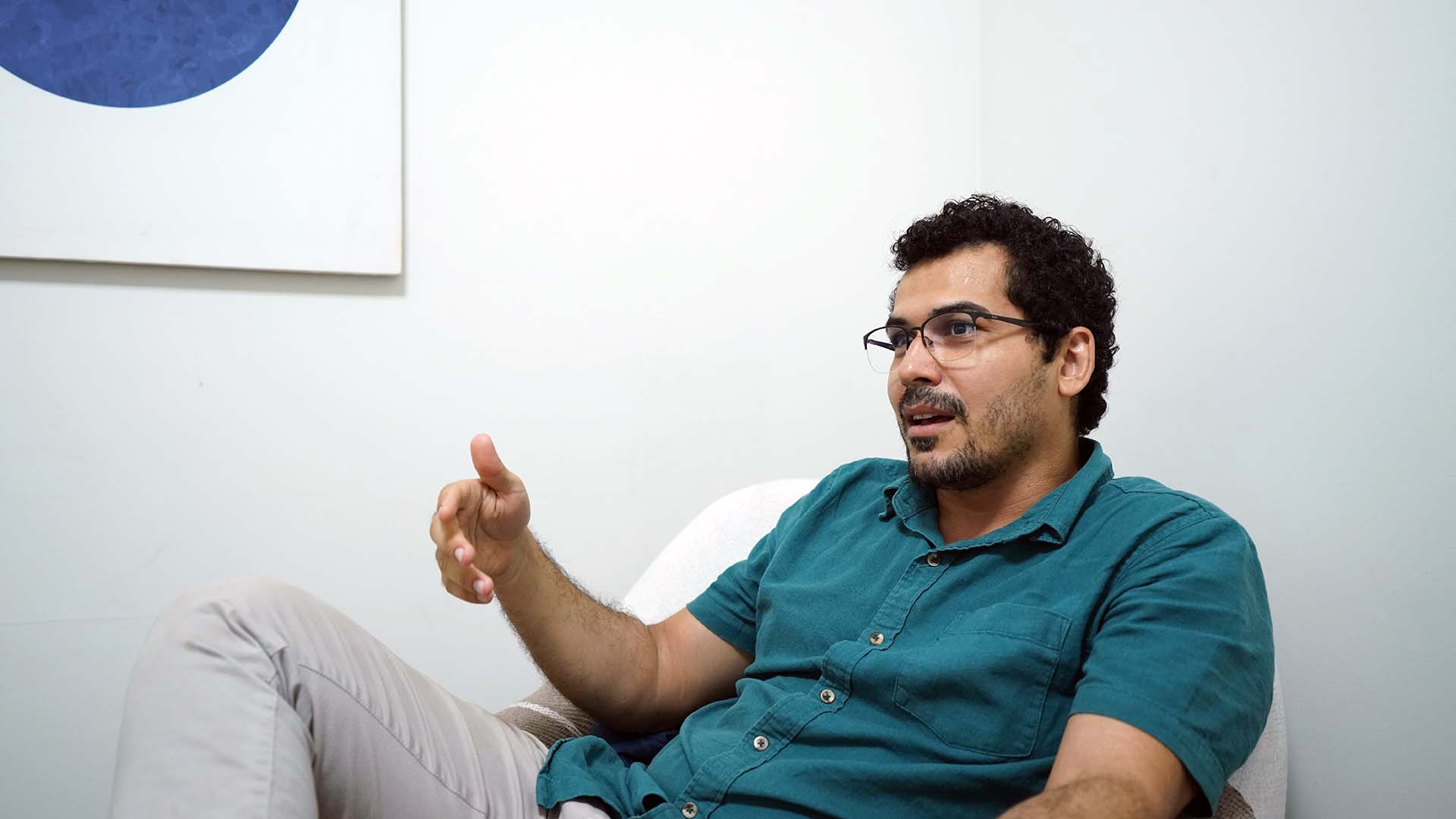 Tássio Soares, psicólogo do Tribunal de Justiça, de camisa verde sentado gesticulando