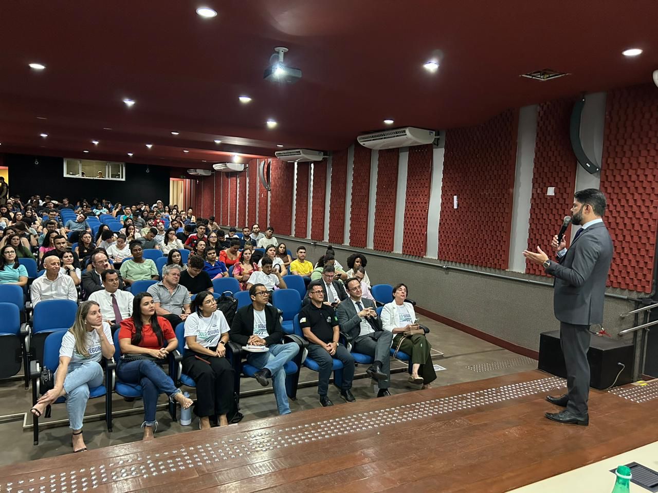 Juiz segurando microfone e falando para alunos