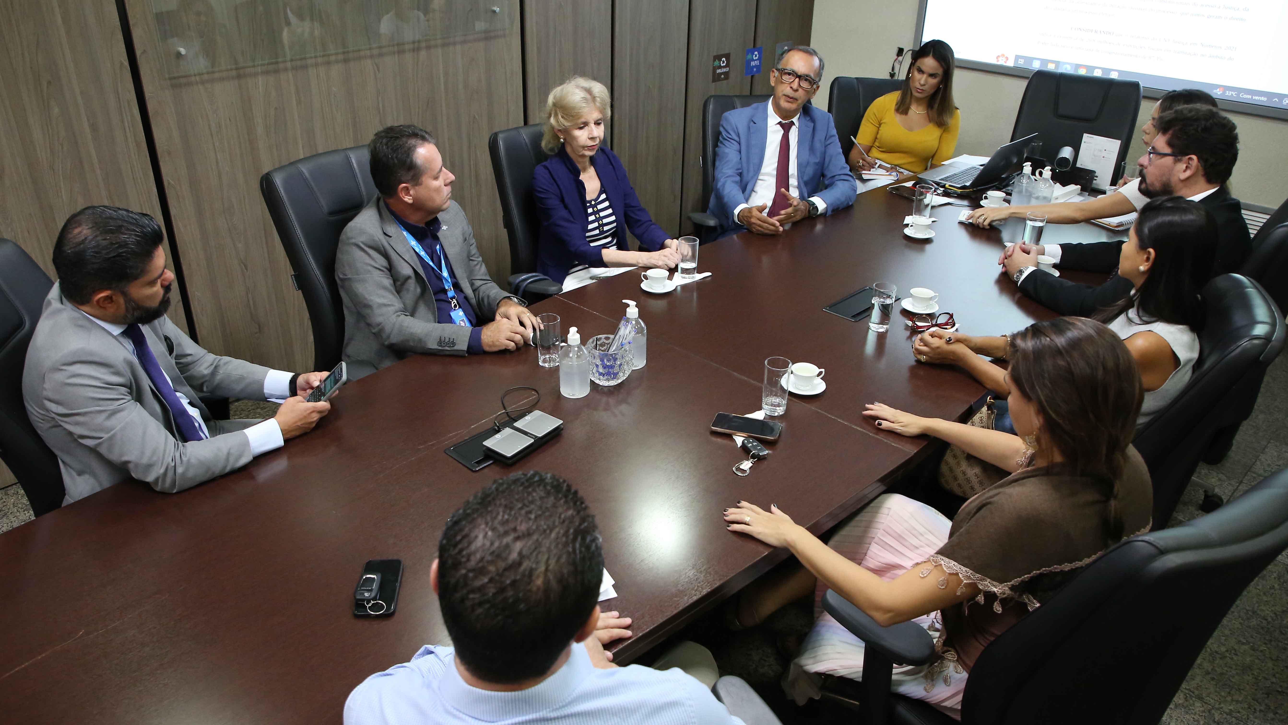 Homens e mulheres sentados à mesa durante reunião