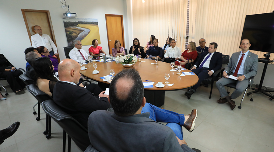 Homens e mulheres em volta de uma mesa 