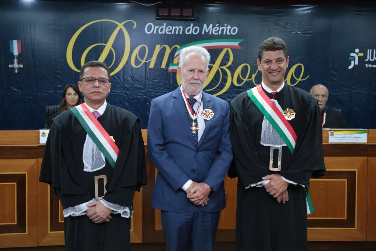 Imagem colorida de três homens engravatados e com uma honraria no peito