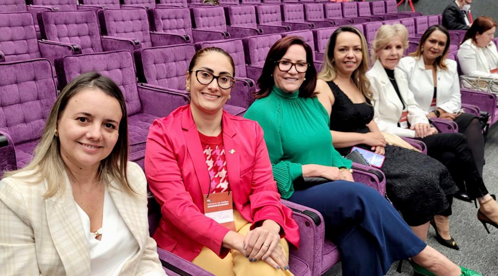 mulheres representantes do tjto sentadas em cadeiras lilases posam para foto
