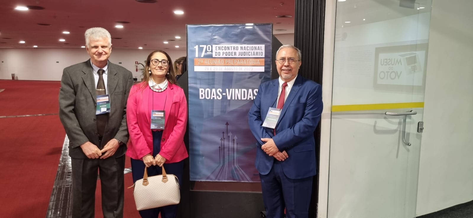 dois homens e uma mulher posam para foto