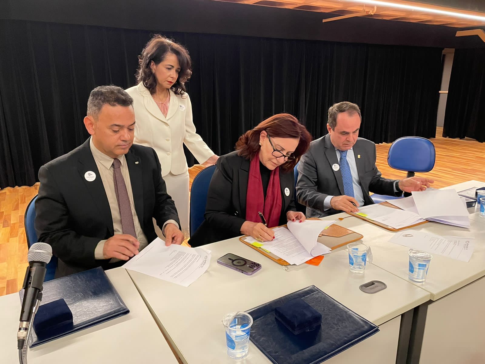 Homens e mulheres bem vestidos posam para foto em frente à escadaria da USP, em São Paulo