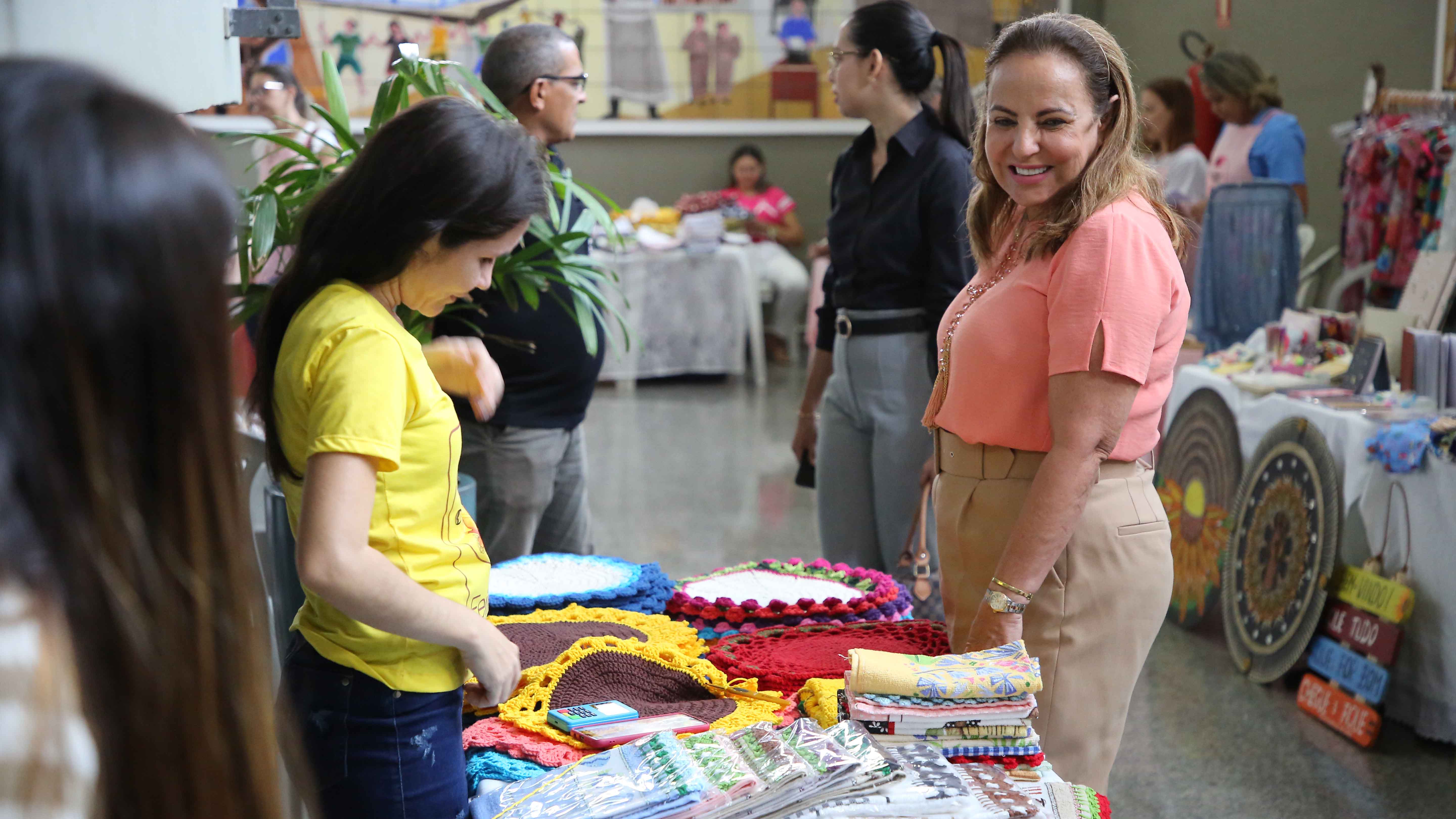 desembargadora ângela prudente olhando produtos expostos na feira