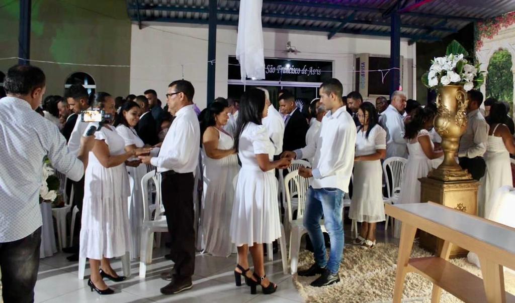 casais de mãos dadas celebram casamento comunitário