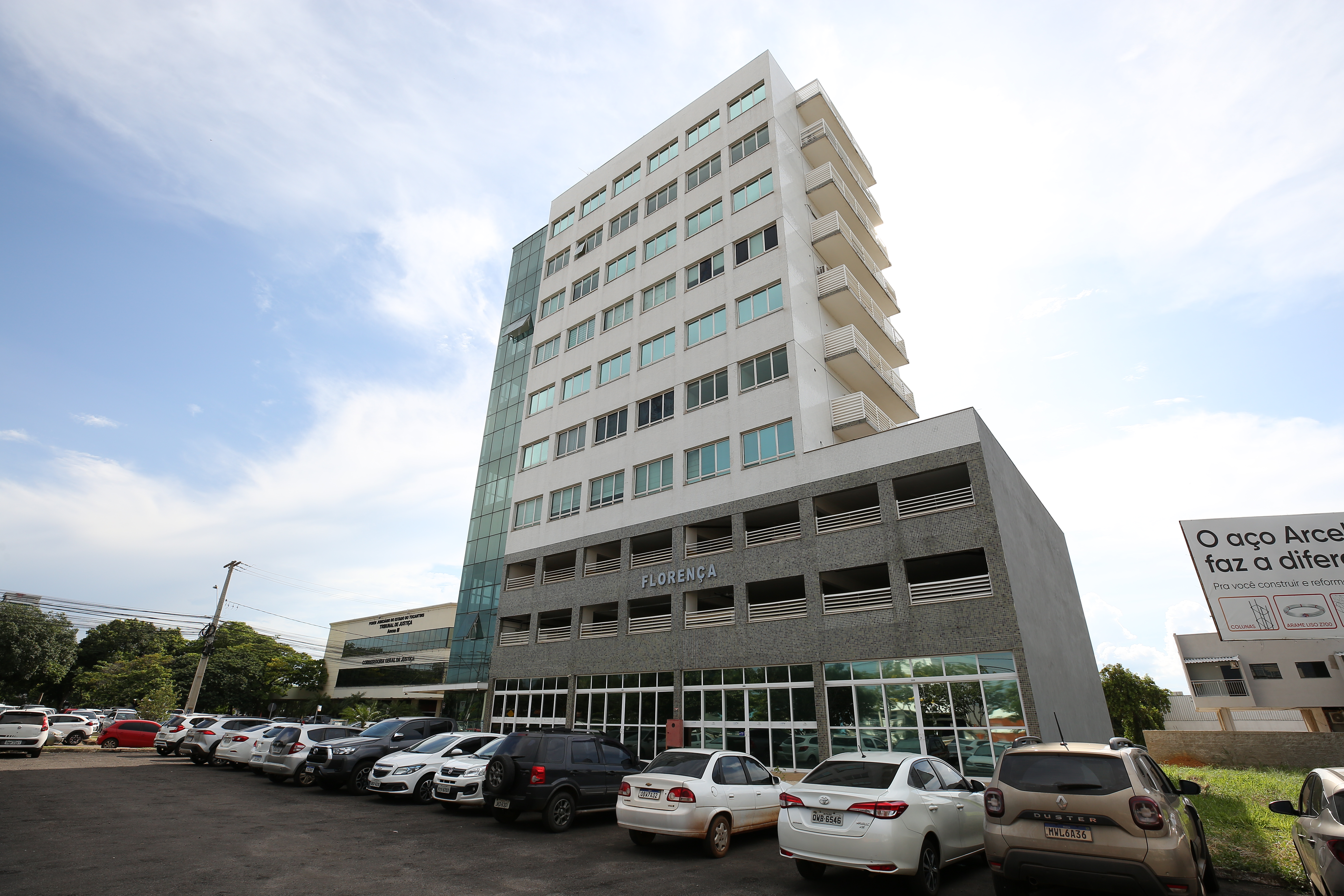 Fachada de prédio cinza com portas de vidro no térreo