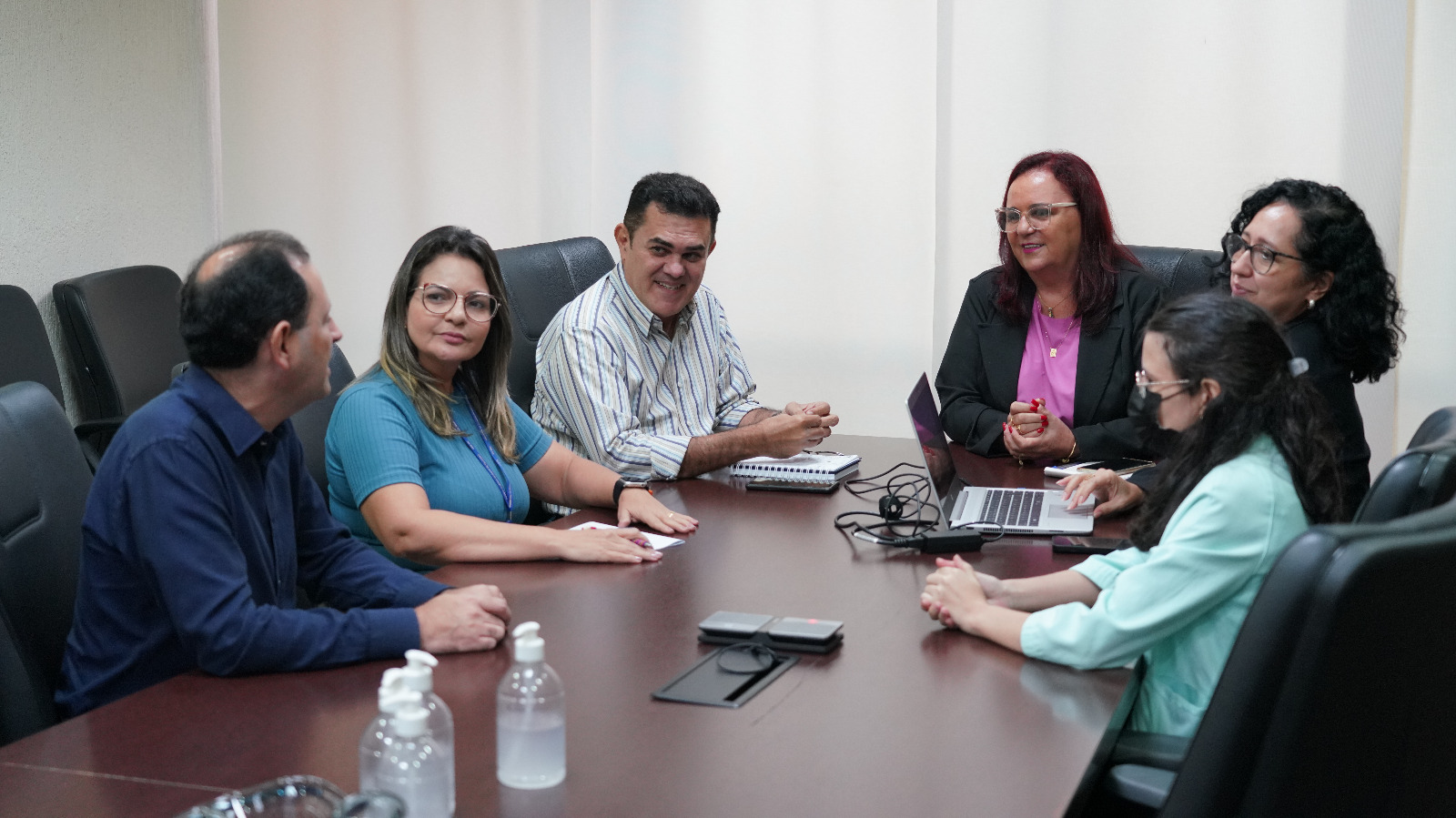 quatro mulheres e três homens sentados à mesa