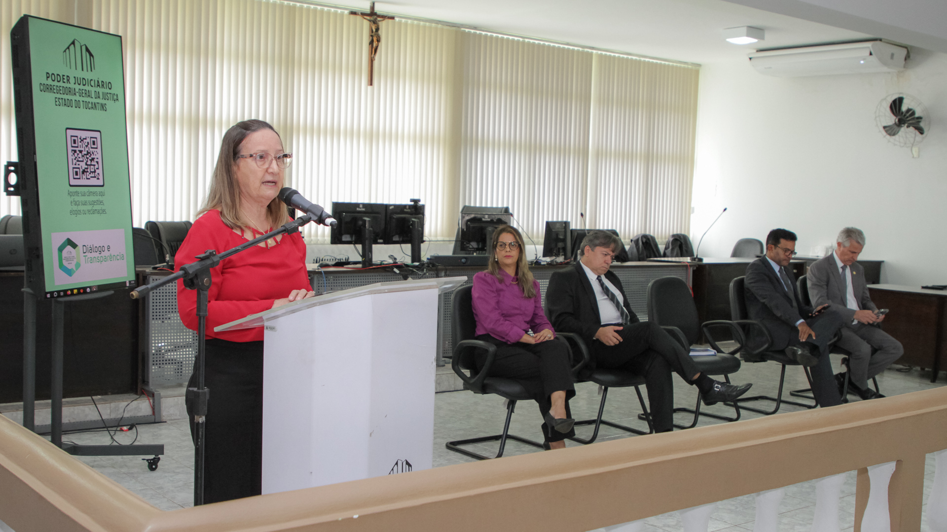 Desembargadora Maysa Vendramini, de blusa vermelha, falando para público presente
