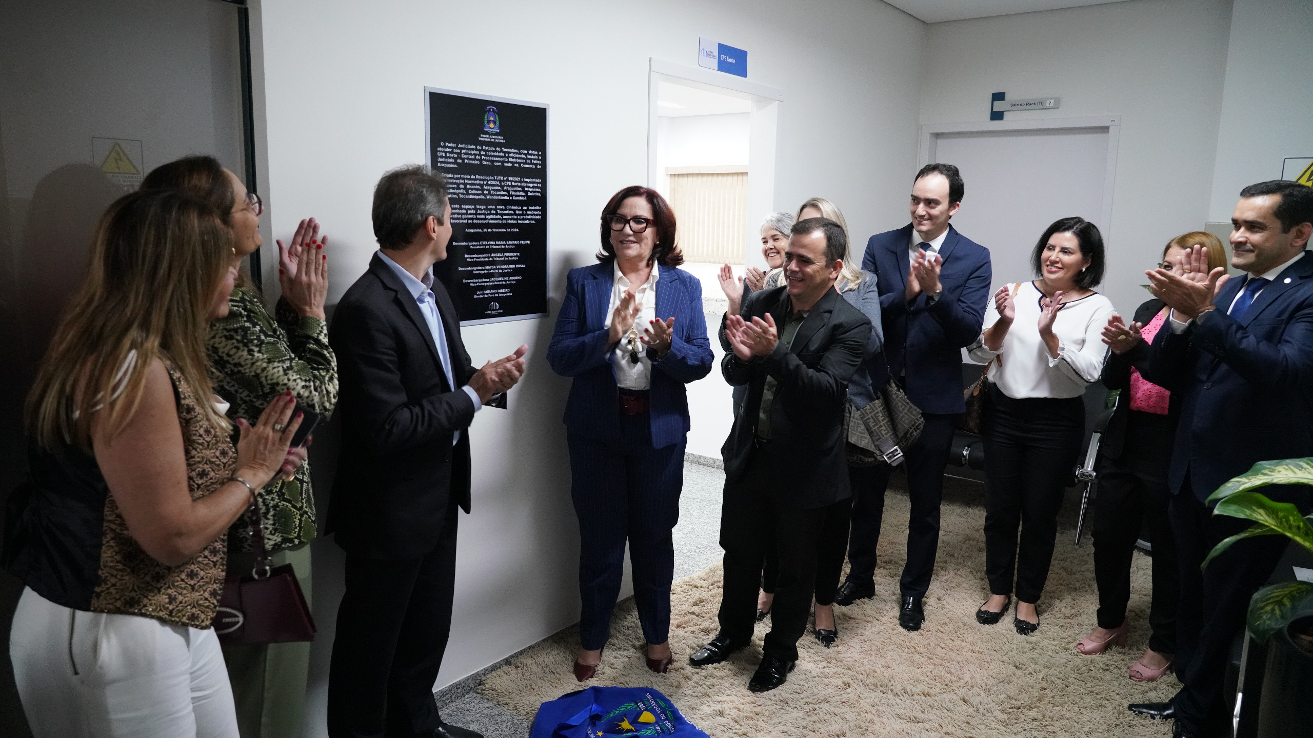 Fotografia colorida onde a Presidente do Tribunal de Justiça do Tocantins, desembargadora Etelvina Maria Sampaio Felipe, tira um pano azul que cobria a placa da nova CPE juntamente da equipe da Comarca de Araguaína