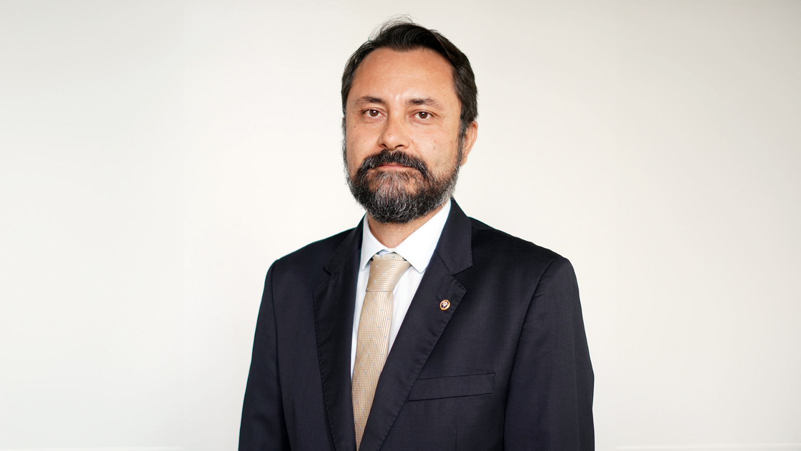 Juiz Rodrigo Perez, um homem de barba e cabelos escuros; usa blazer escuro, camisa branca e gravata bege