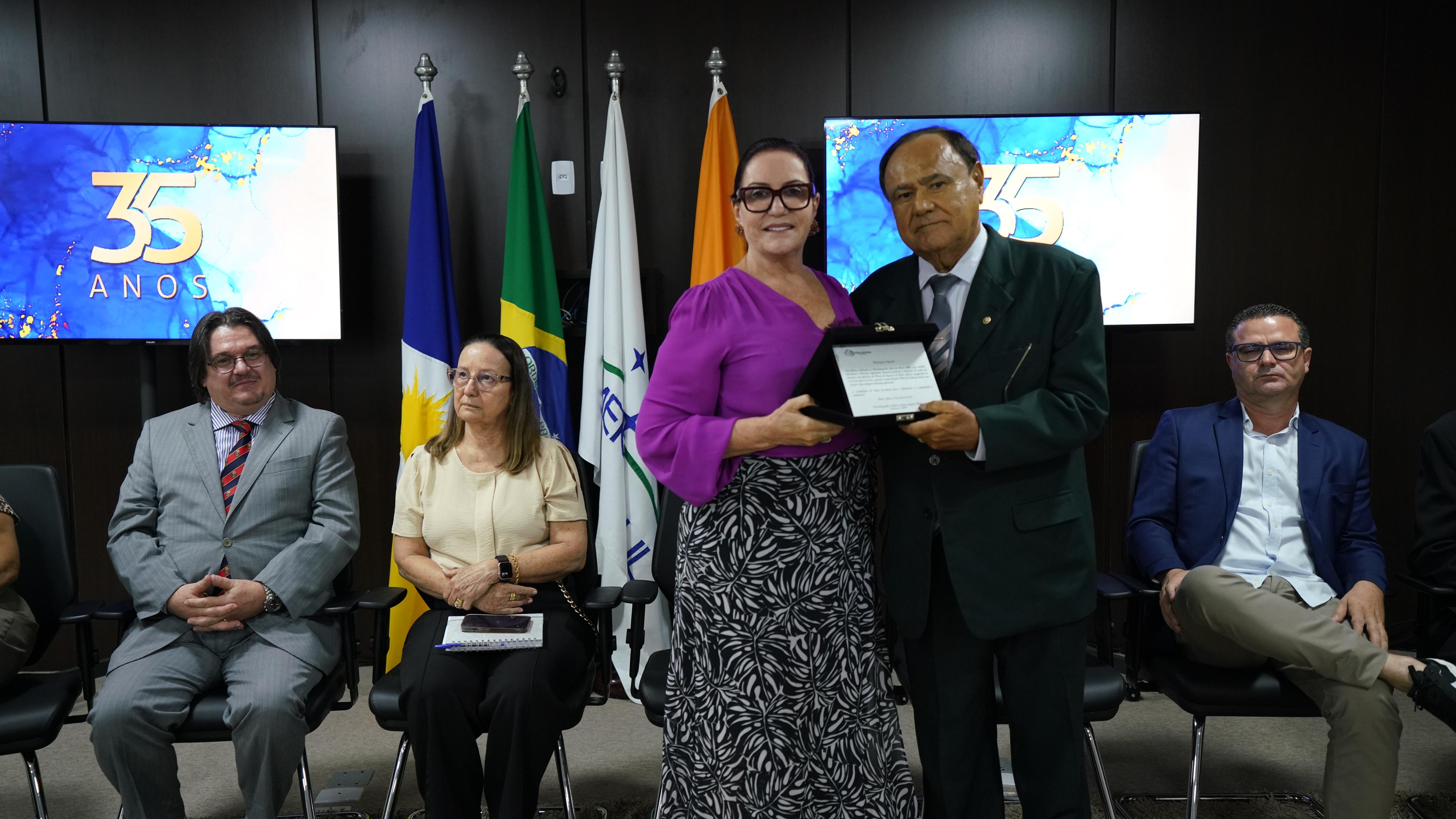 Mulher entrega homenagem a homem durante evento na comarca de Pedro Afonso