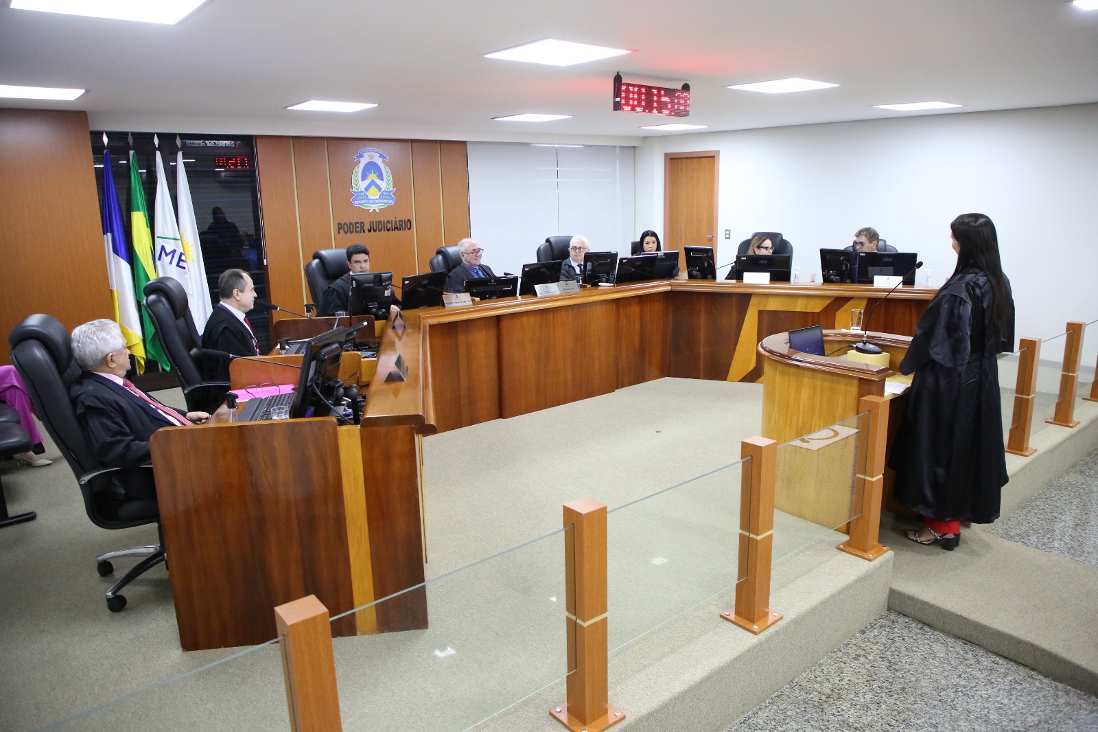 Fotografia colorida que mostra homens e mulheres usando preto e participando de uma sessão na Câmara Criminal