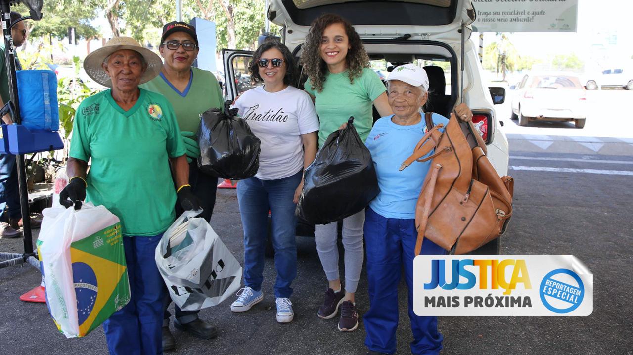 Três mulheres catadoras de materiais recicláveis e duas servidoras do Poder Judiciário do Tocantins com sacolas, em pé, em frente a um veículo com o porta-malas aberto, durante drive-thru da coleta solidária na porta do Tribunal de Justiça 