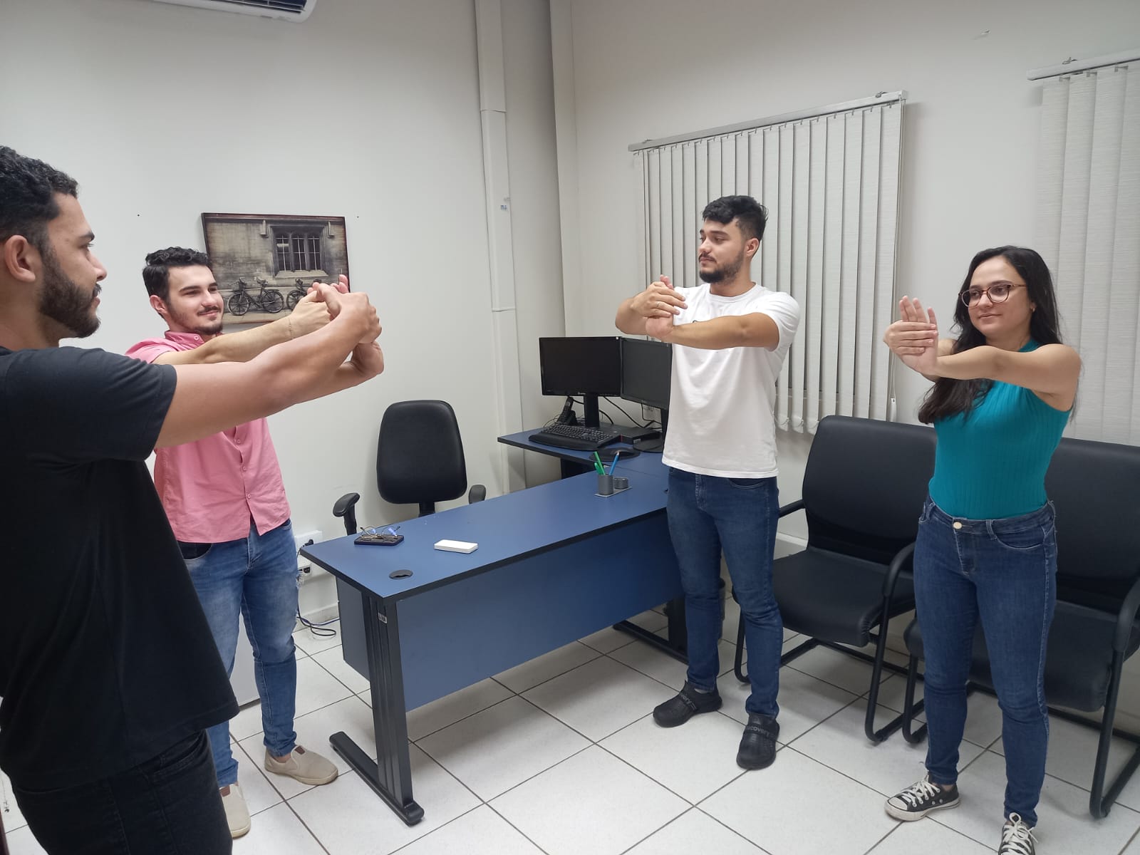 Imagem mostra pessoas em pé e uma sentada fazendo movimentos no punho