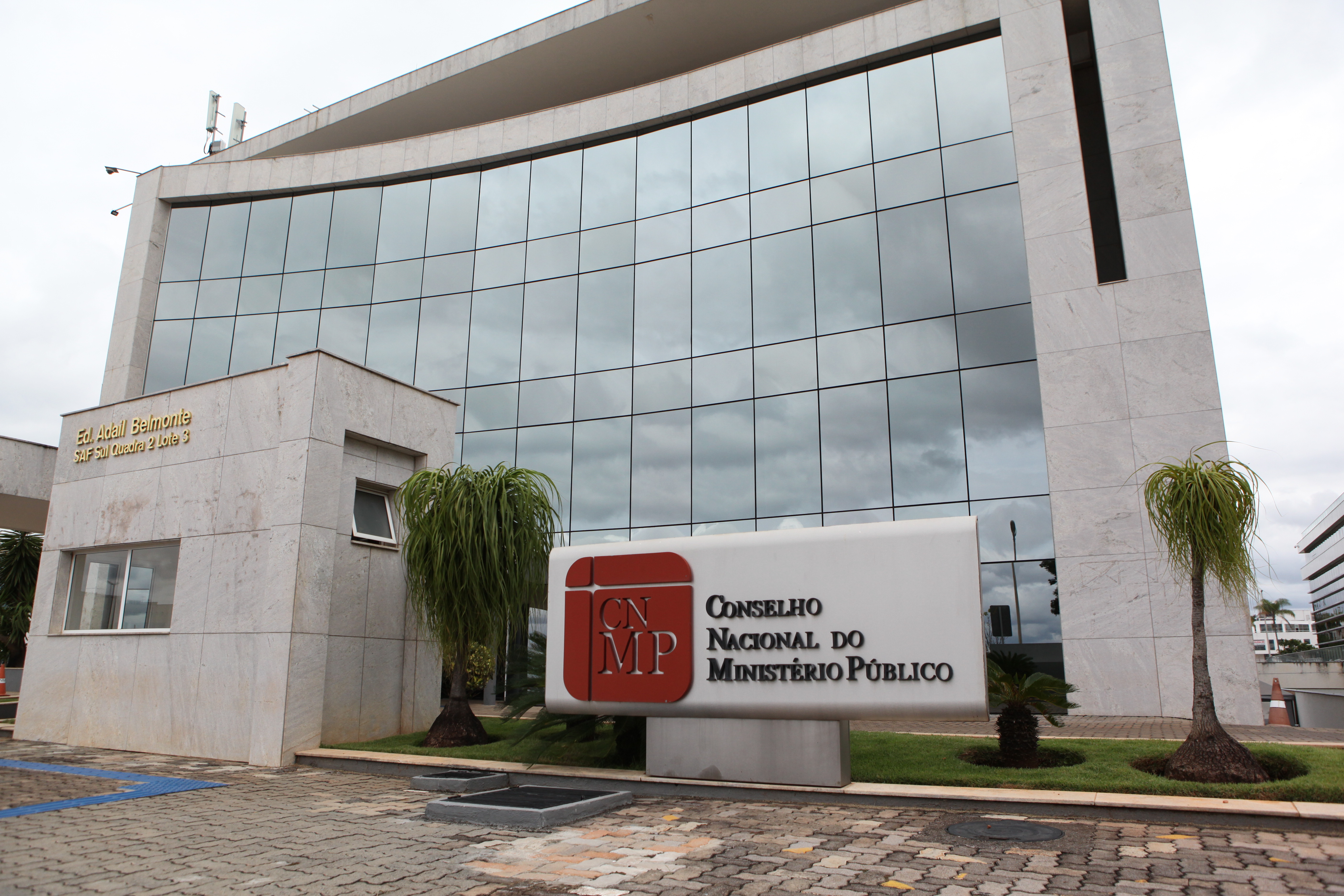 Foto mostra a fachada do CNMP; prédio é espelhado e é pintado com cor clara