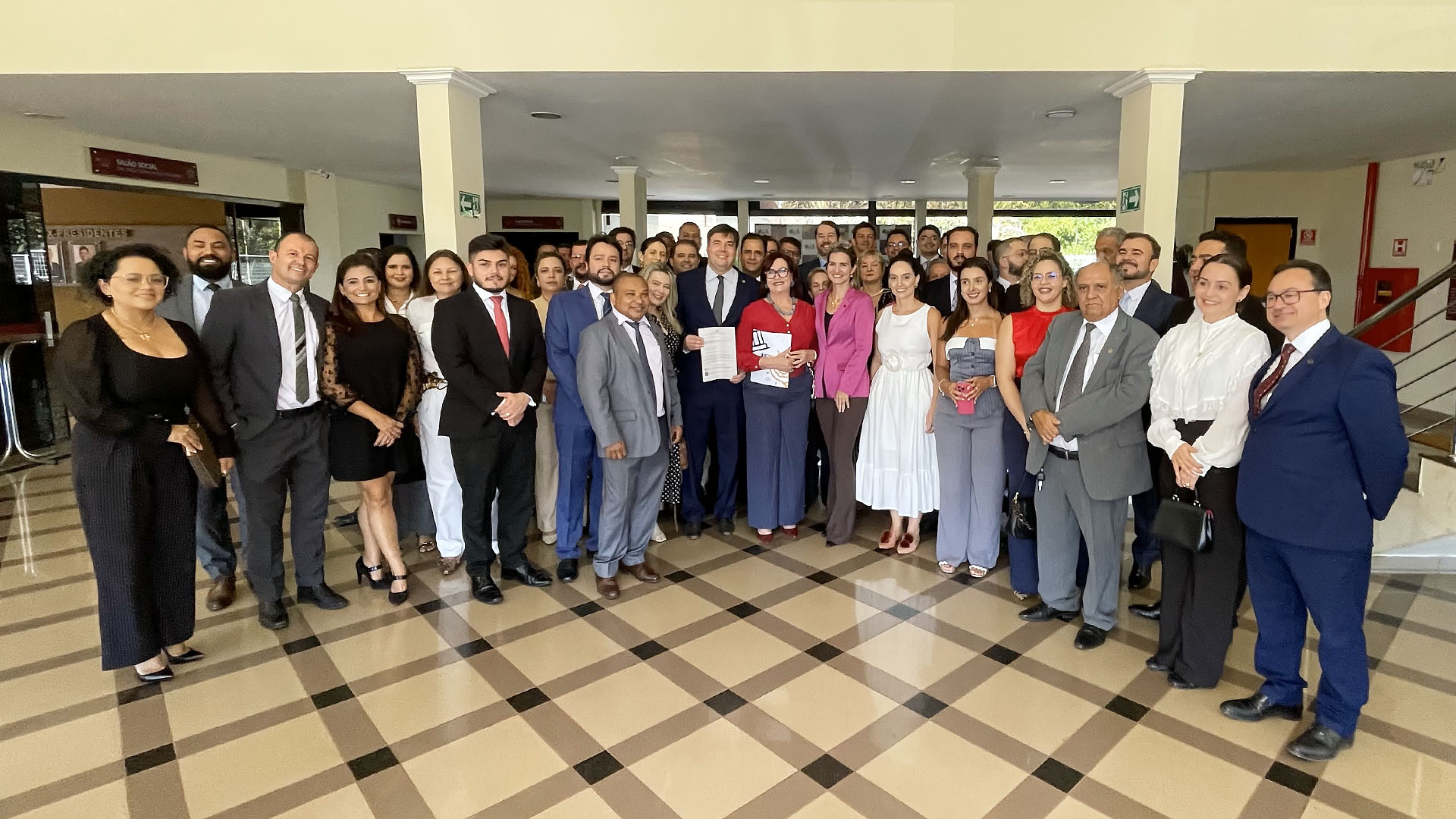 Imagem mostra várias pessoas em pé posando para foto