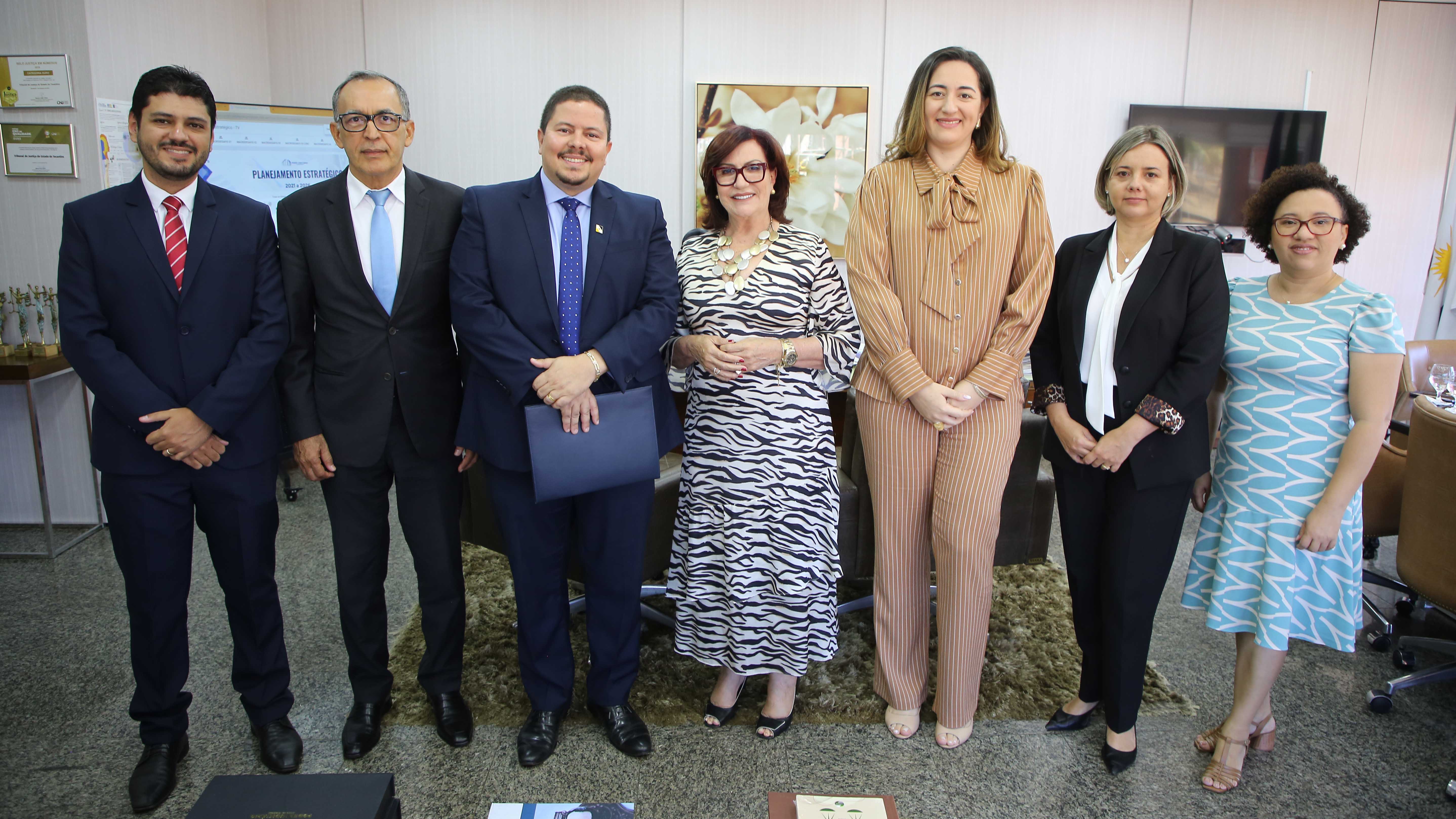 Homens e mulheres posam para uma foto na sala da Presidência do TJTO