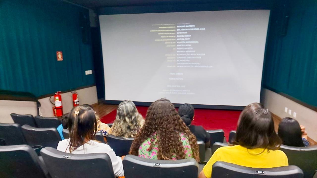 mulheres assistem a projeção de imagem em uma tela branca