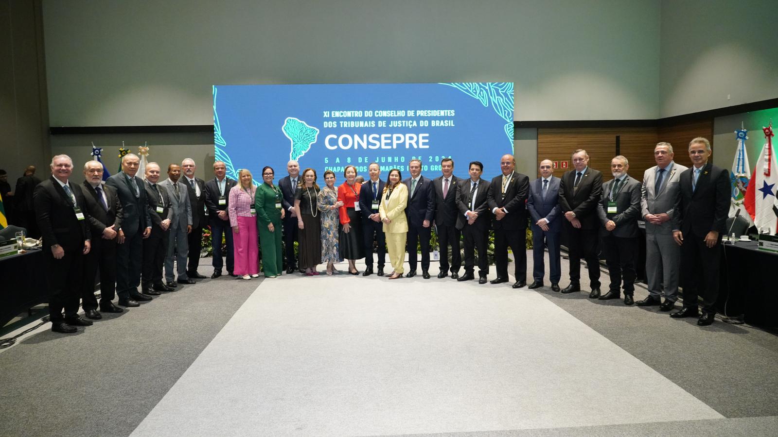 Fotografia colorida que mostra autoridades (homens e mulheres) posando à frente de um painel escrito Consepre
