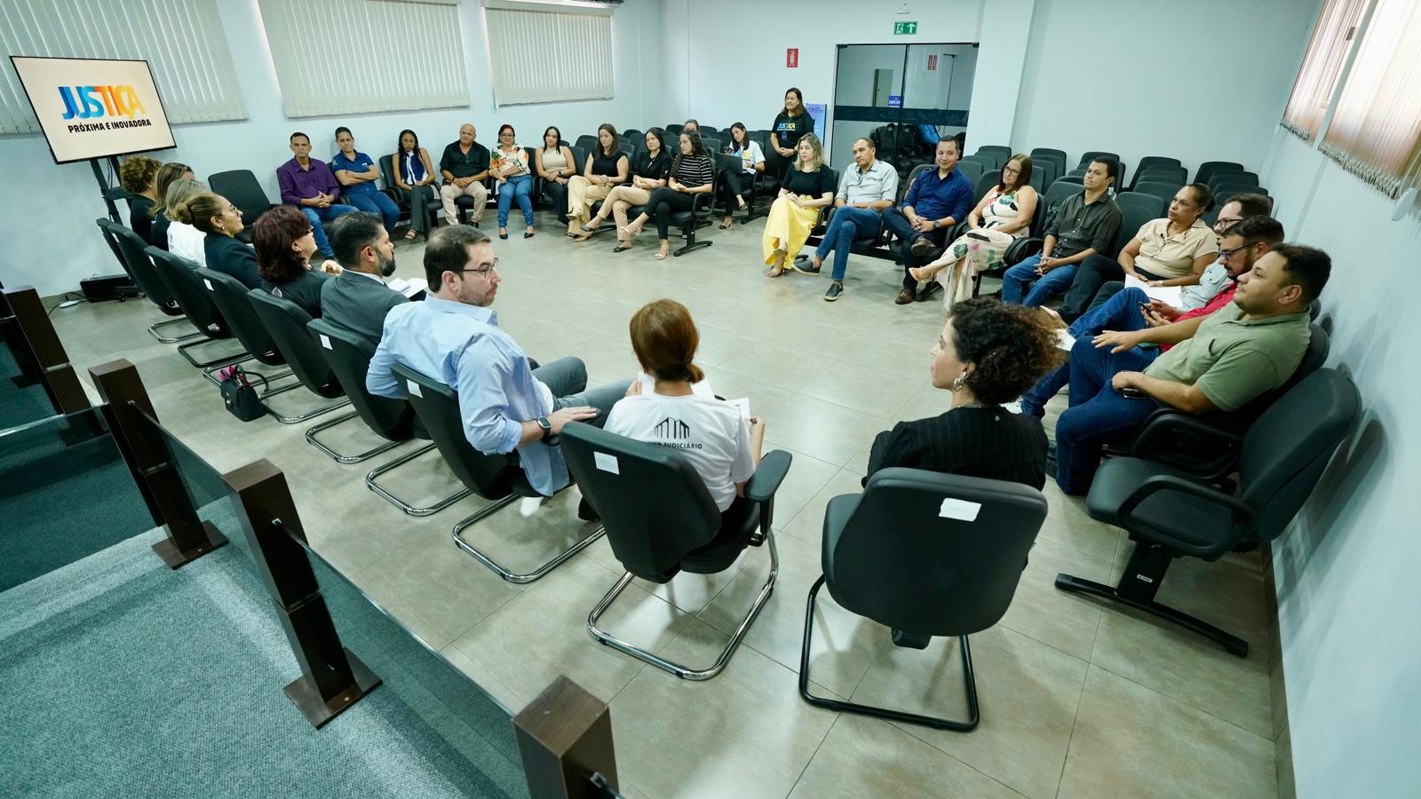 Pessoas sentadas em uma sala do Tribunal do Júri em um bate-papo
