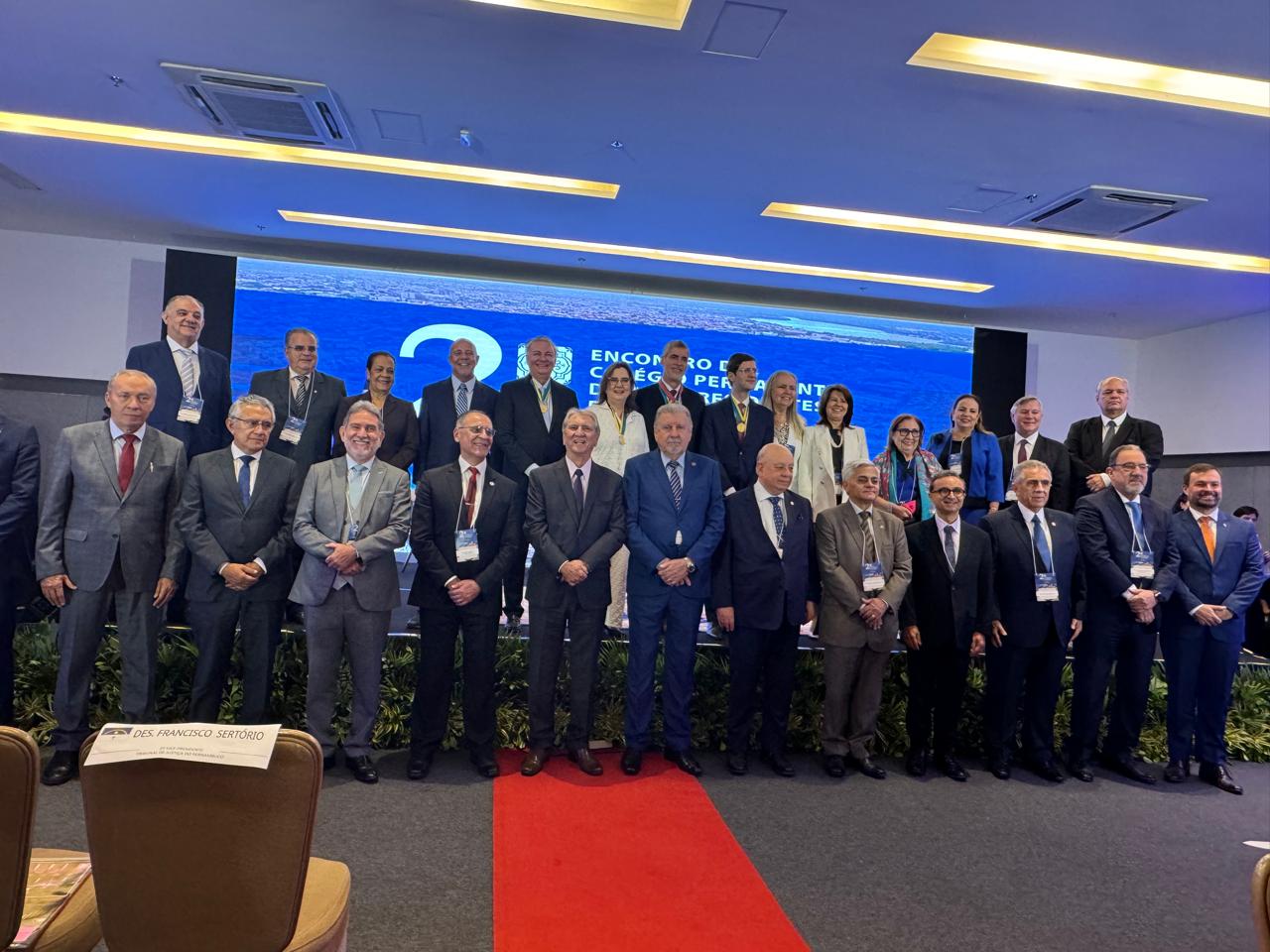 Imagem mostra várias pessoas em pé posando para foto