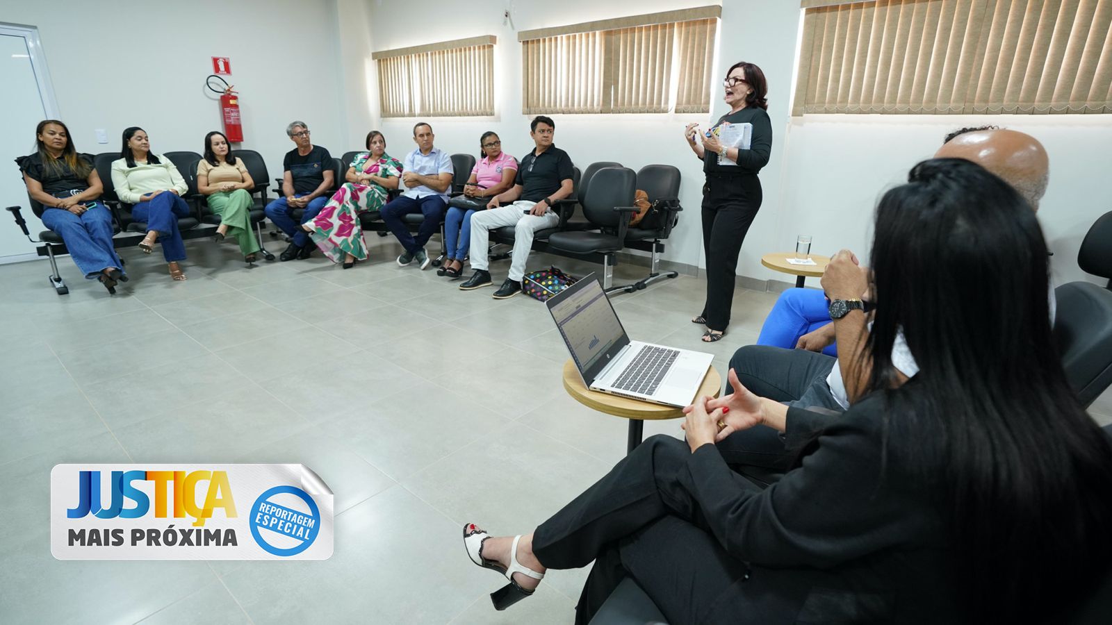 Imagem colorida que mostra a presidente do TJTO conversando para uma plateia atenta em uma sala fechada