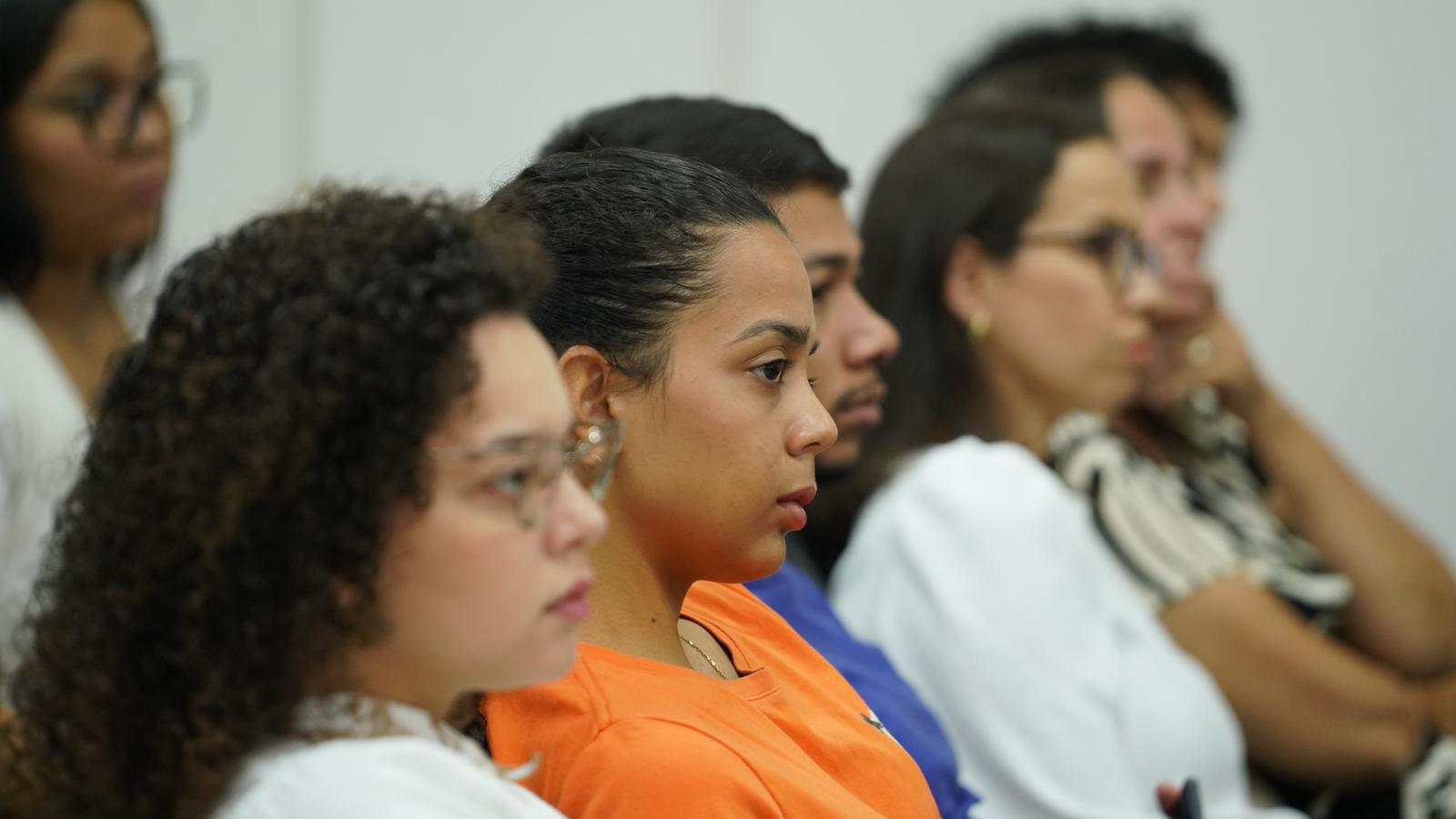 Fotografia colorida que mostra pessoas atentas a alguma informação (foto fechada)