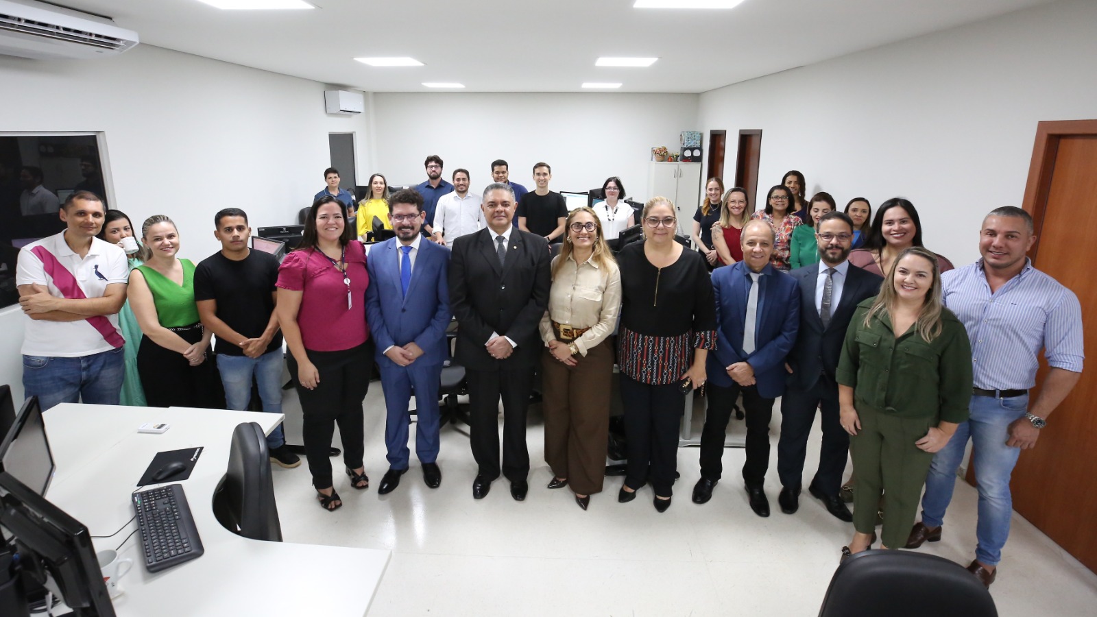 Seis magistrados sendo quatro homens e duas mulheres e vários servidores, entre pessoas do sexo masculino e feminino, em pé, de frente na sala onde vai funcionar o cartório do bloco de competência Criminal