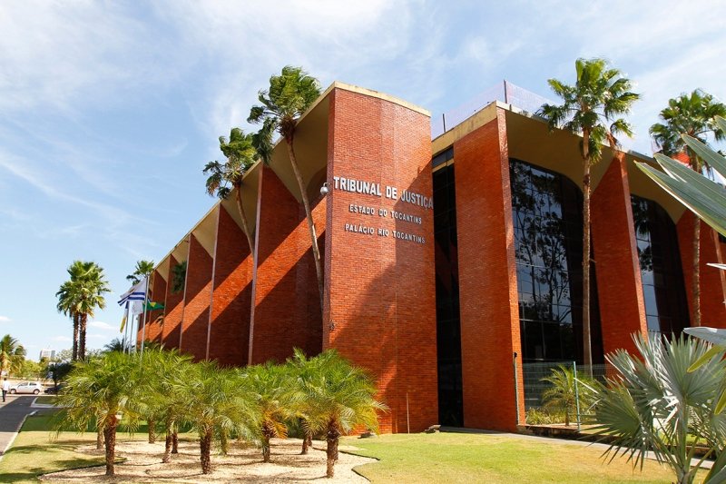 Fachada do prédio do Tribunal de Justiça do Tocantins vista lateral, com seus arcos e vidraças fumê e palmeiras