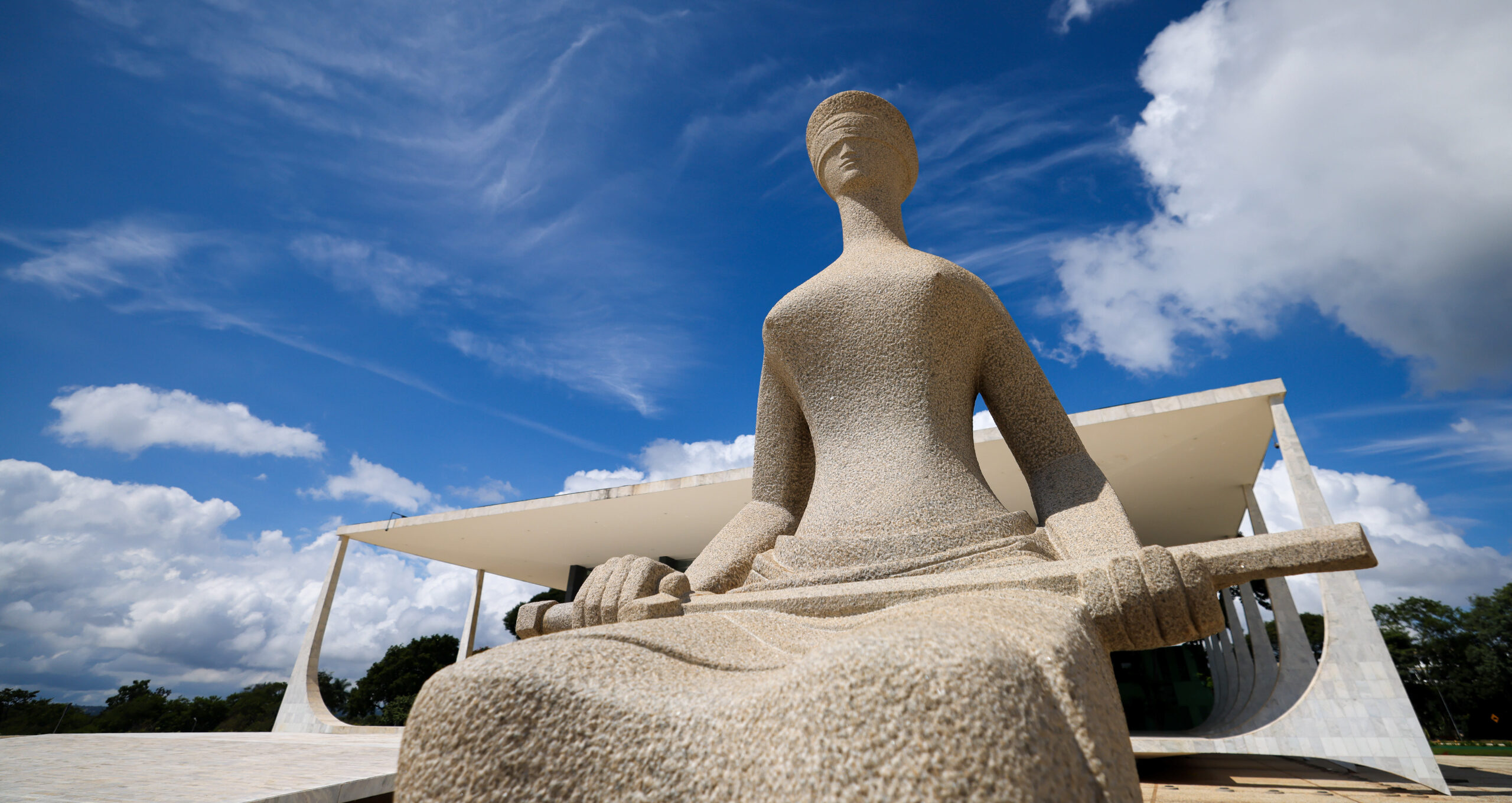 Fotografia colorida da estatua de Têmis, em frente ao prédio do STF