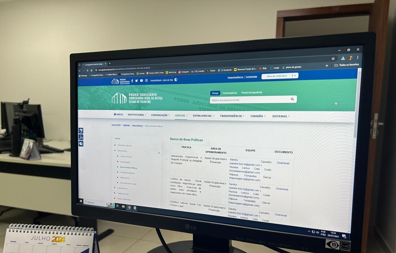 Fotografia colorida da tela de um computador em cima de uma mesa, com um calendário ao lado. Nessa tela. está aberta uma página sobre as boas práticas no site da Corregedoria Geral de Justiça do Tocantins 